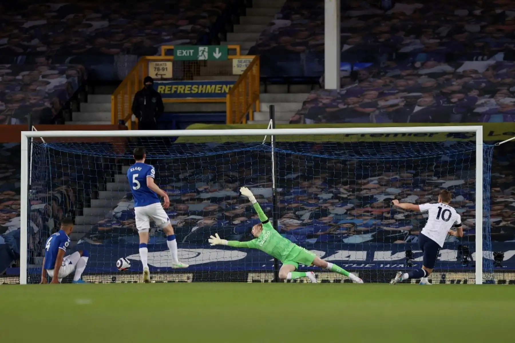 El delantero inglés del Tottenham Hotspur Harry Kane (R) anota el gol de apertura durante el partido de fútbol de la Premier League inglesa entre el Everton y el Tottenham Hotspur en Goodison Park en Liverpool. Foto: AFP