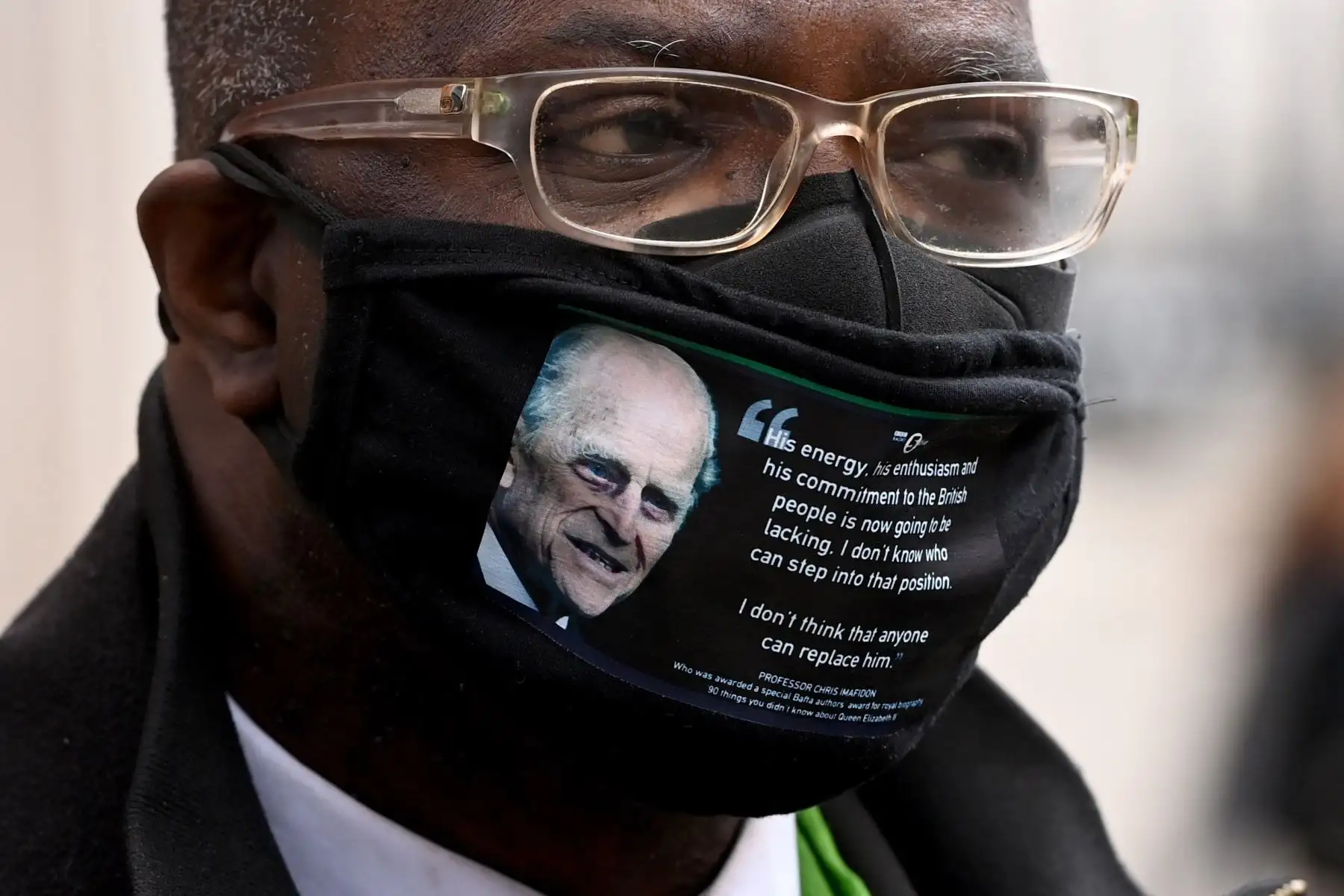 Un hombre ataviado con una mascarilla con la imagen y una frase del príncipe Felipe, duque de Edimburgo, camina cerca del Castillo de Windsor, en Reino Unido.
Foto: EFE