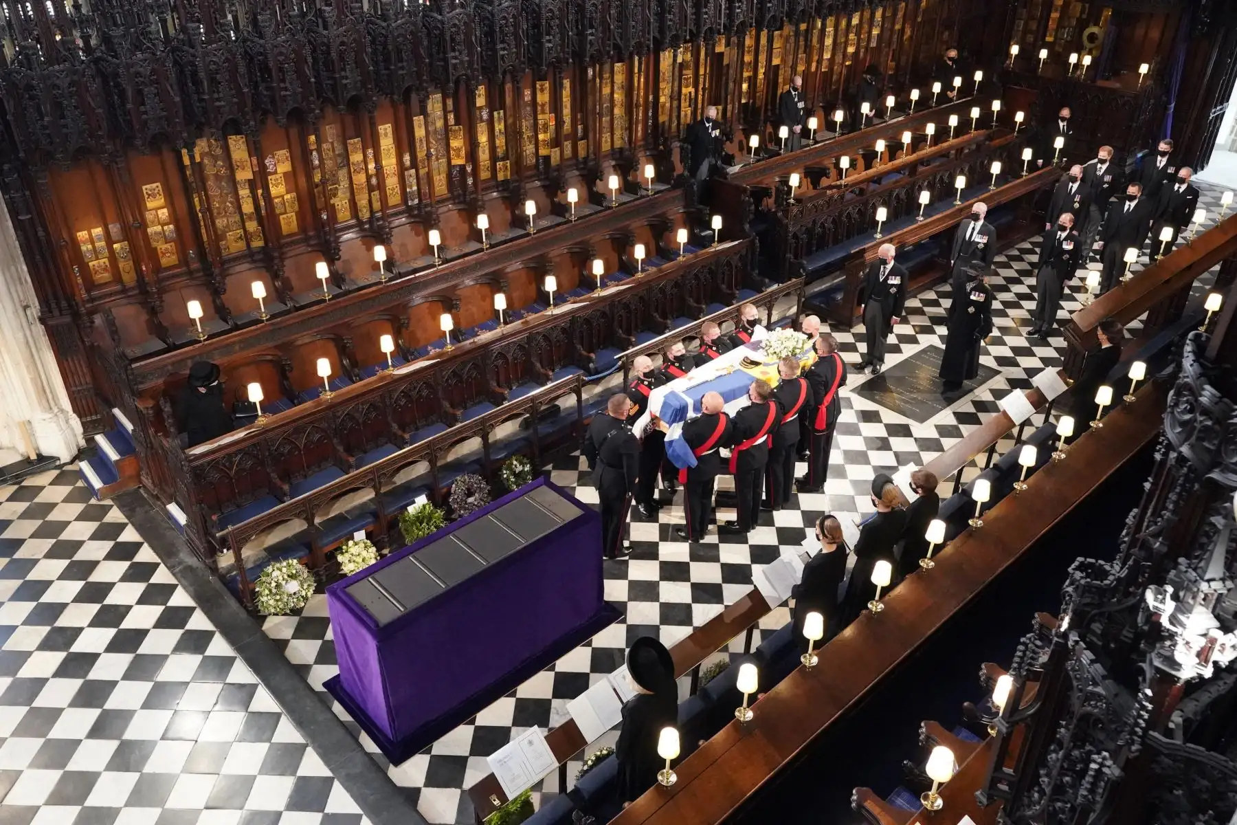 La reina Isabel II observa cómo los portadores del féretro llevan el ataúd del príncipe Felipe de Gran Bretaña, duque de Edimburgo, durante su funeral dentro de la Capilla de San Jorge en el Castillo de Windsor.
Foto: AFP