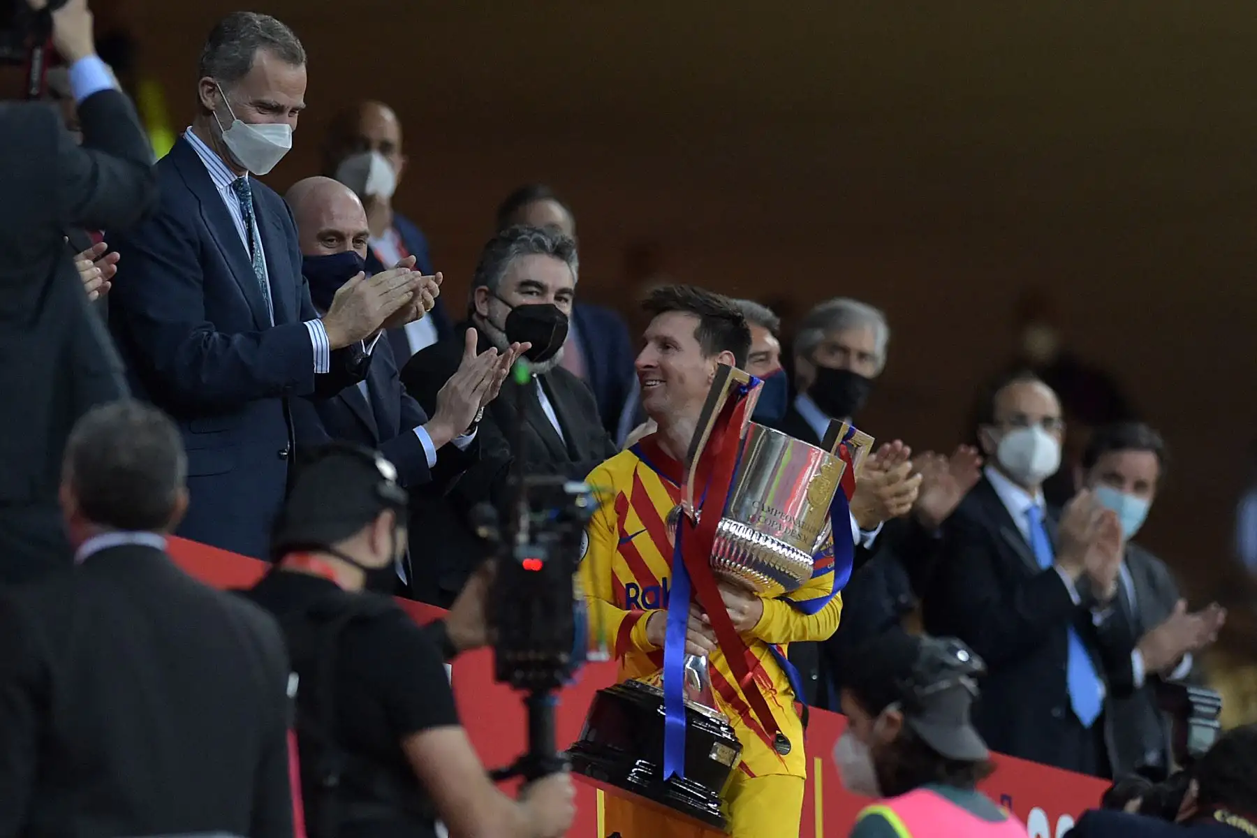 El delantero argentino del Barcelona Lionel Messi sostiene el trofeo después de recibirlo de manos del rey Felipe VI (izq.) De España al final de la final de la Copa del Rey de España entre el Athletic Club de Bilbao y el FC Barcelona en el estadio de La Cartuja de Sevilla. Foto: AFP
