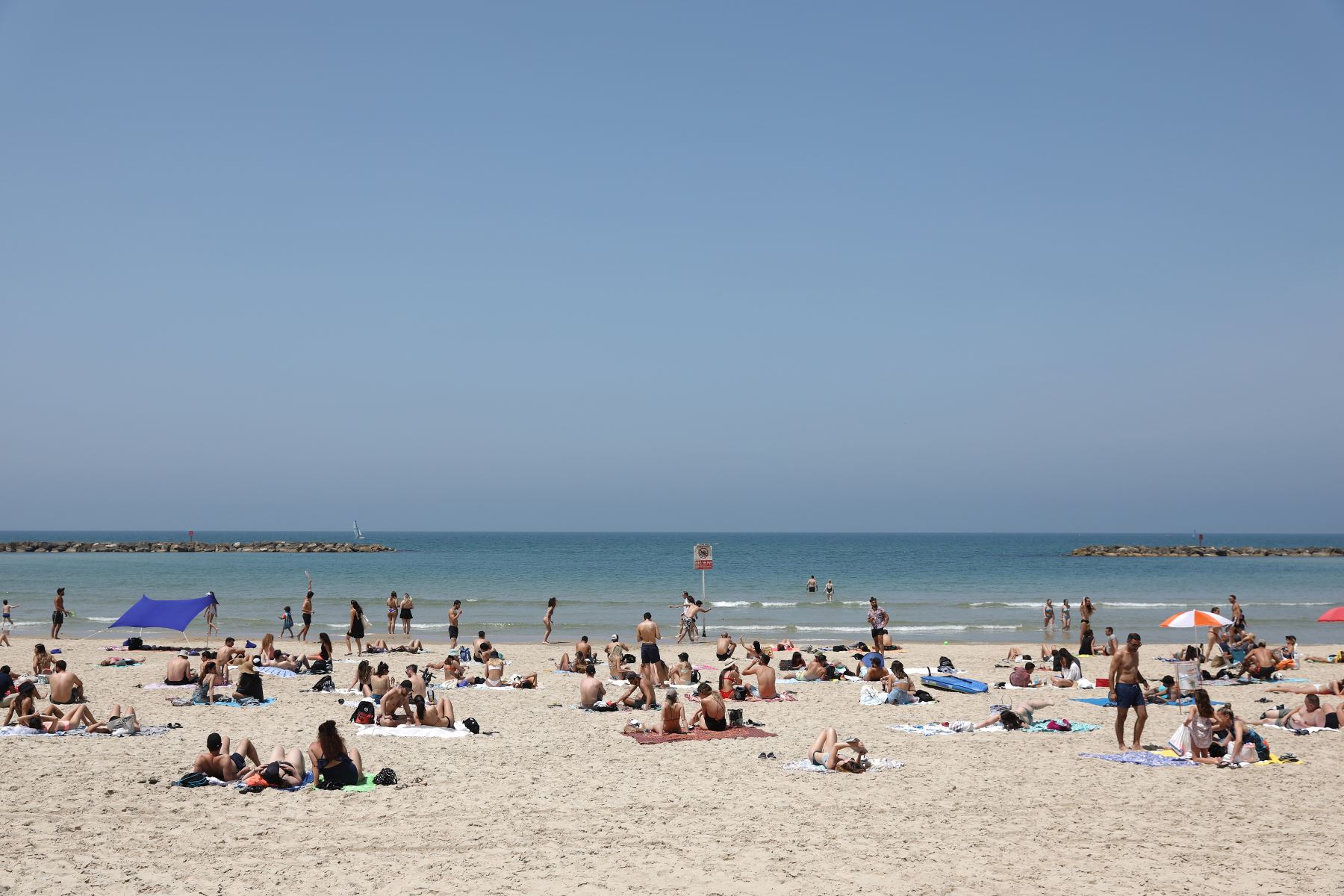 Personas sin mascarillas disfrutan del tiempo en la playa de Tel Aviv, 17 de abril de 2021. Foto: EFE