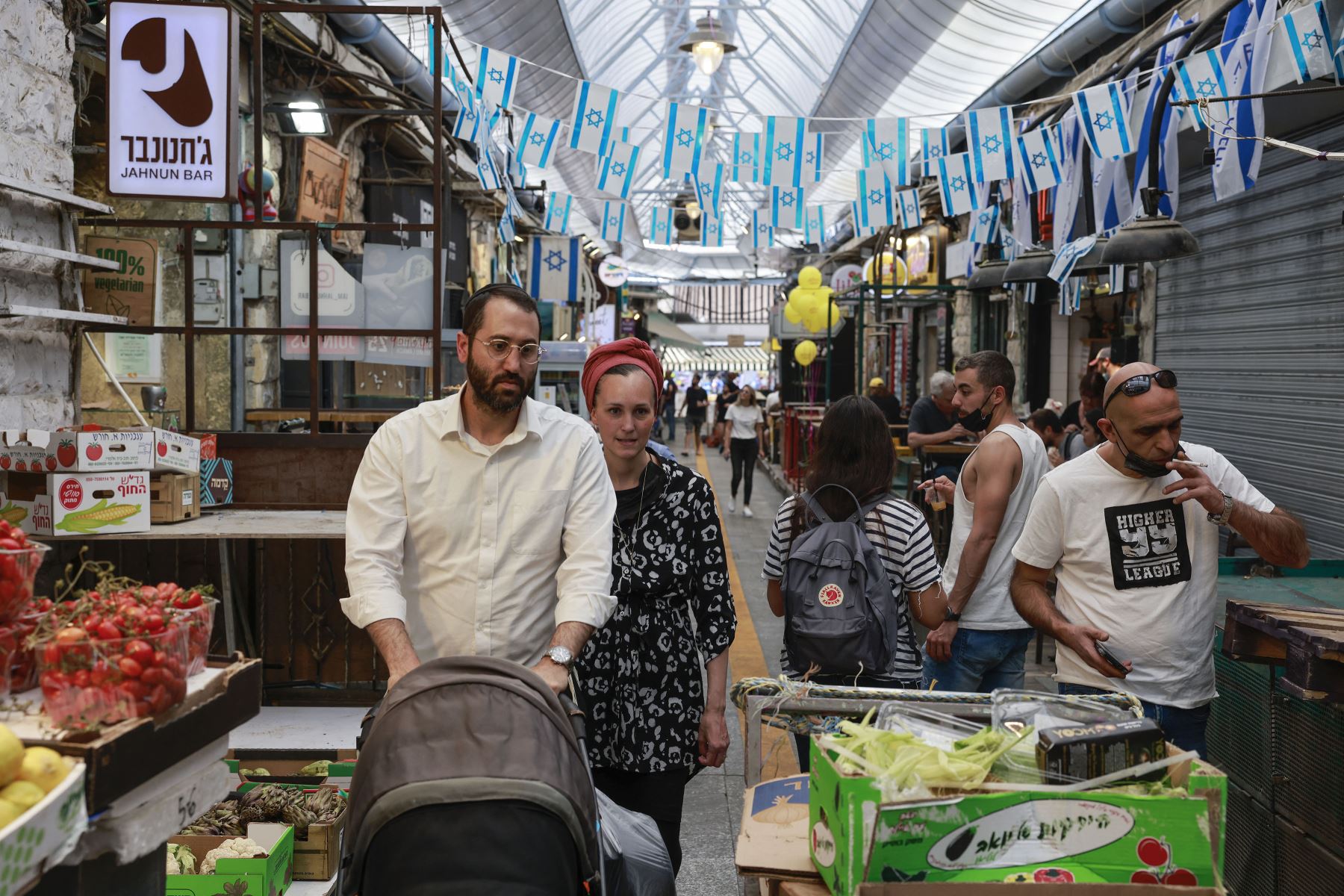 La gente compra en un mercado en Jerusalén, el 18 de abril de 2021, después de que las autoridades israelíes anunciaran que las mascarillas para la prevención del COVID-19 ya no eran necesarias al aire libre. Foto: AFP