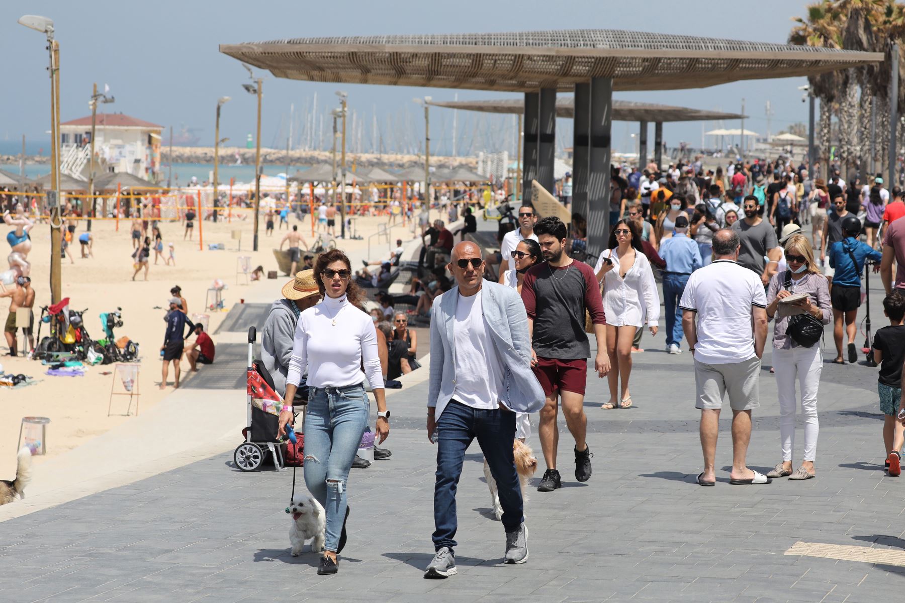 Personas sin mascarillas disfrutan del día en la playa de Tel Aviv, el 17 de abril de 2021. Israel pone fin al uso obligatorio de mascarillas al aire tras una exitosa campaña de vacunación. Foto: EFE