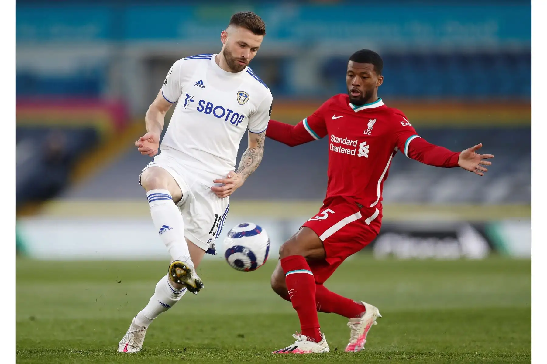 Stuart Dallas del Leeds United en acción con Georginio Wijnaldum del Liverpool durante el partido de fútbol de la Premier League. Foto: EFE