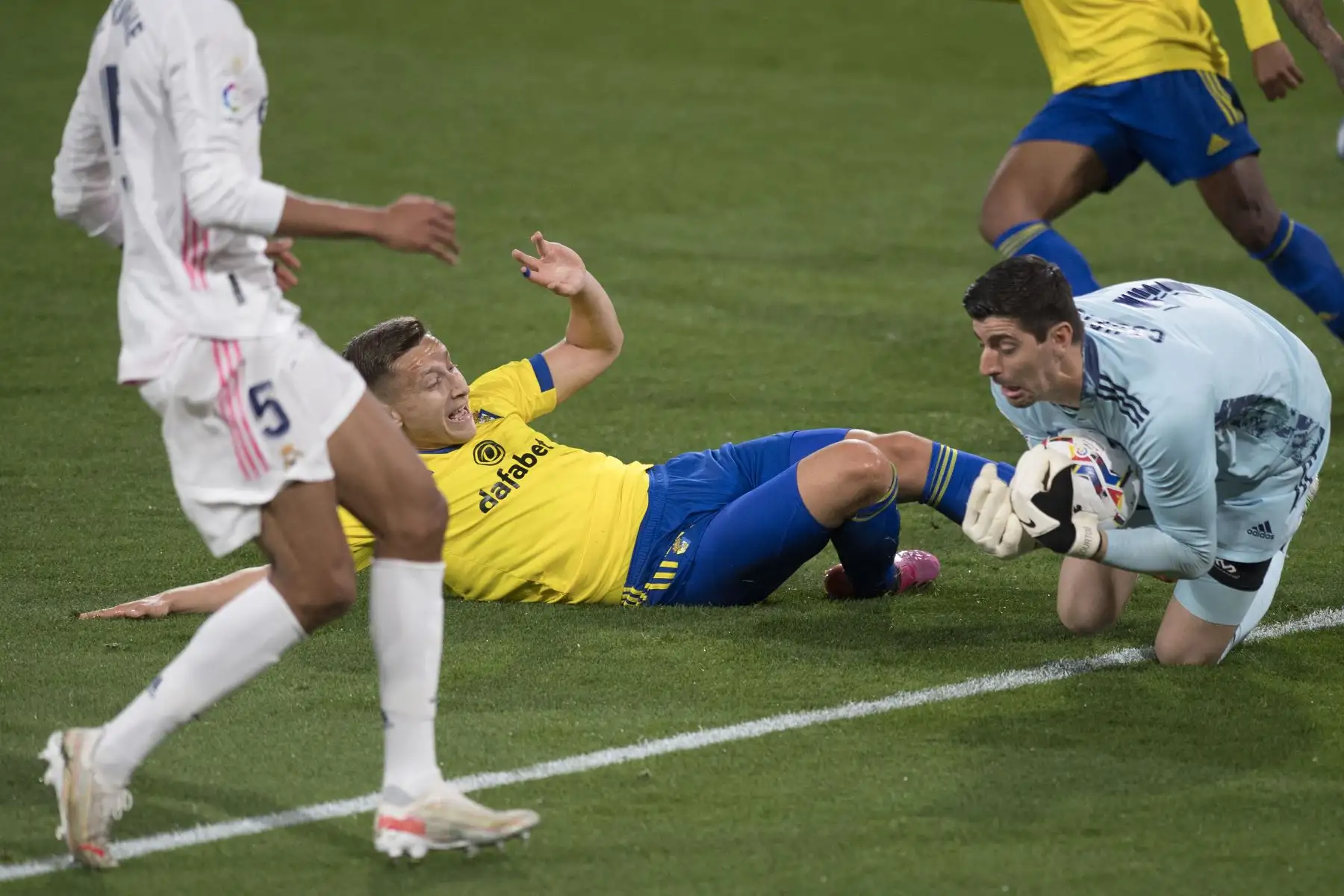 El portero belga del Real Madrid Thibaut Courtois  detiene un disparo a portería del delantero serbio del Cádiz Ivan Saponjic durante el partido de fútbol de la Liga española. Foto: AFP
