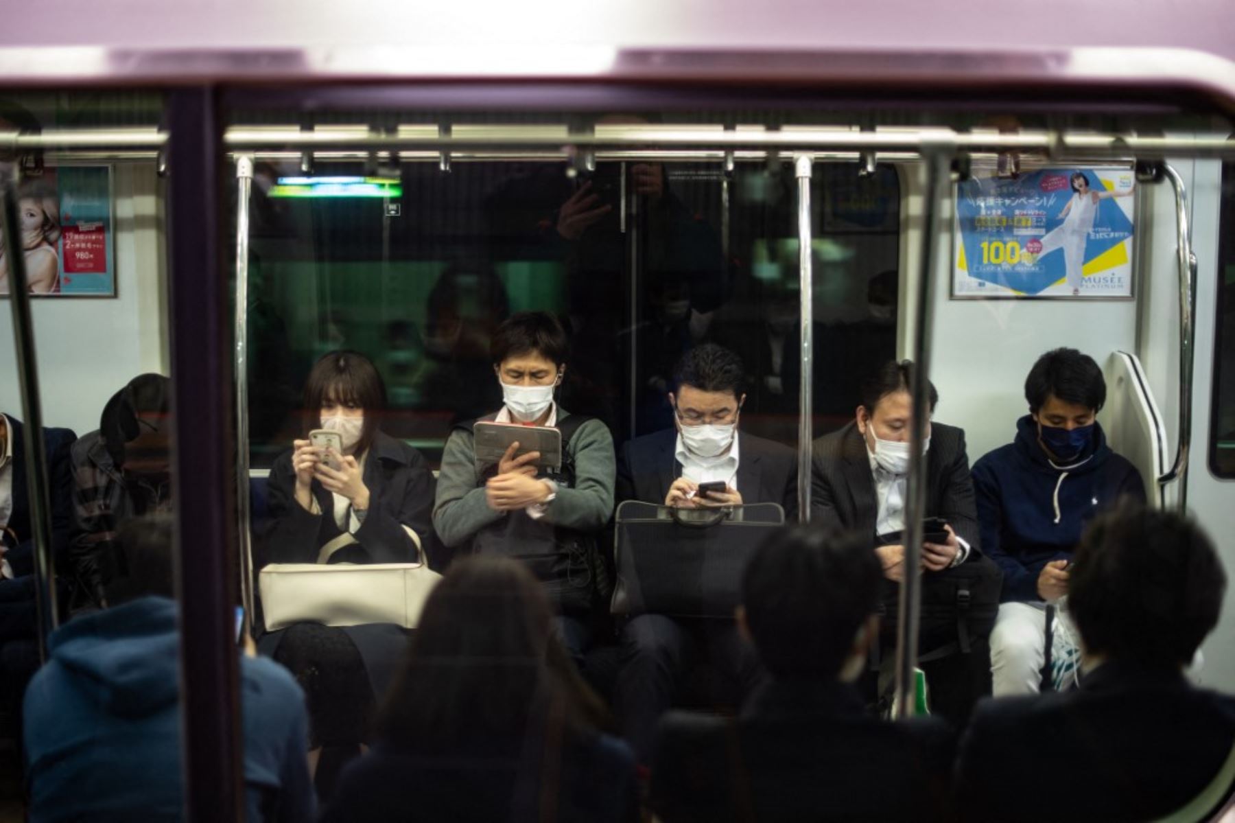 Los viajeros se sientan dentro de un tren en la estación de Shibuya en Tokio, cuando el gobierno de Japón aprobó medidas más estrictas contra el coronavirus para la capital y otras áreas. Foto: AFP