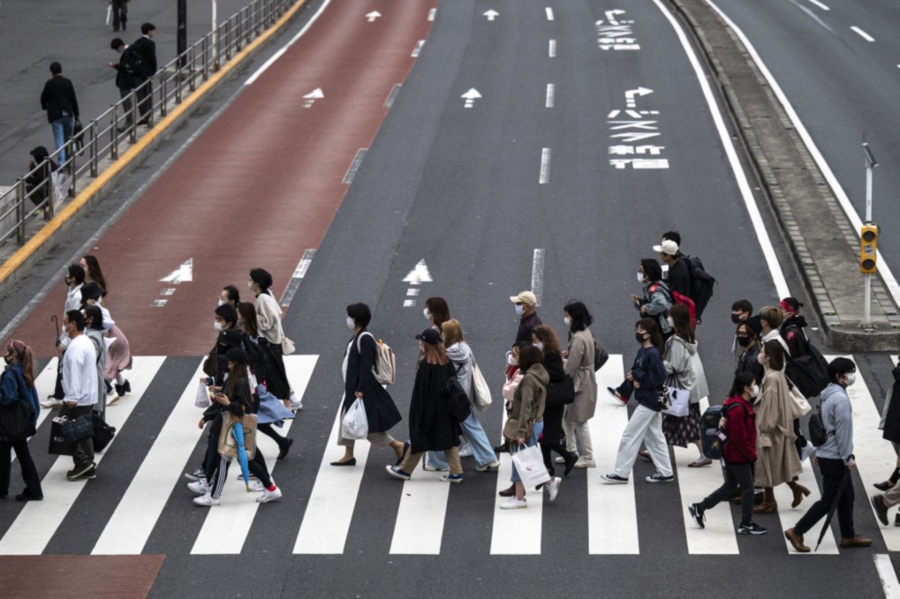 Los peatones cruzan una calle en el área de Shinjuku de Tokio, ya que la ciudad informó 510 nuevas infecciones por coronavirus Covid-19. Foto: AFP