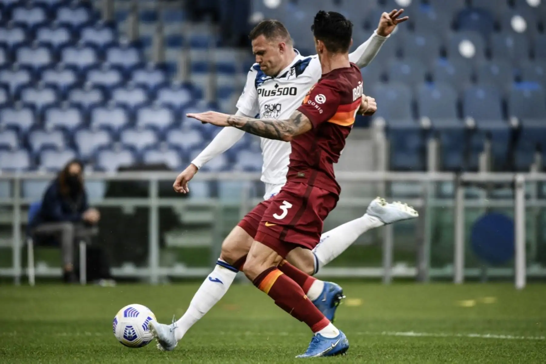 El centrocampista esloveno del Atalanta Josip Ilicic (trasero) dispara a puerta a pesar del defensor brasileño de la Roma Roger Ibáñez durante el partido de fútbol de la Serie A italiana AS Roma vs Atalanta Bergamo el 22 de abril de 2021 en el Estadio Olímpico de Roma. Foto: AFP