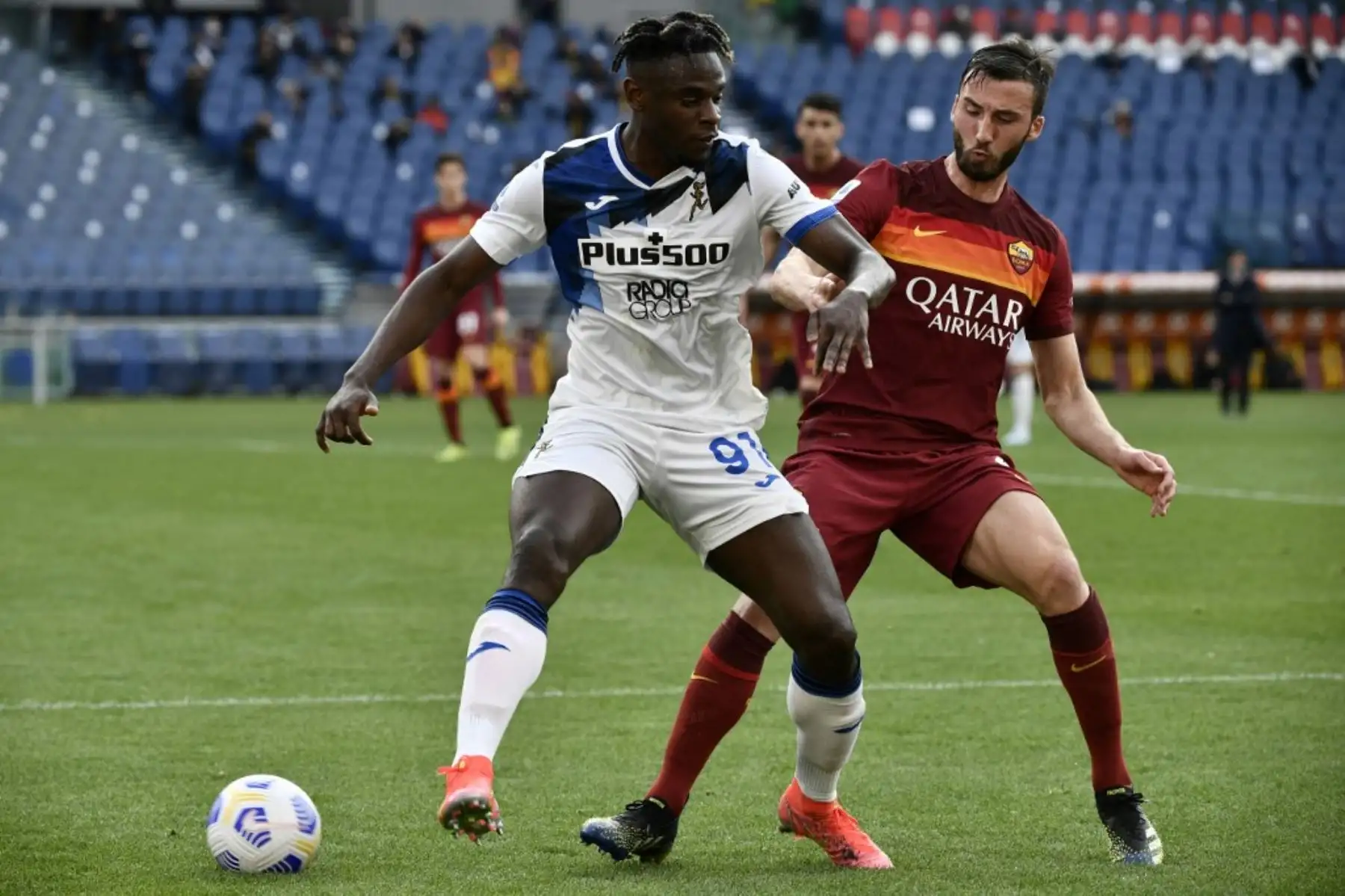 El delantero colombiano del Atalanta, Duvan Zapata (L), trabaja alrededor del mediocampista italiano de la Roma Bryan Christante durante el partido de fútbol de la Serie A italiana AS Roma vs Atalanta Bergamo el 22 de abril de 2021 en el Estadio Olímpico de Roma. Foto: AFP