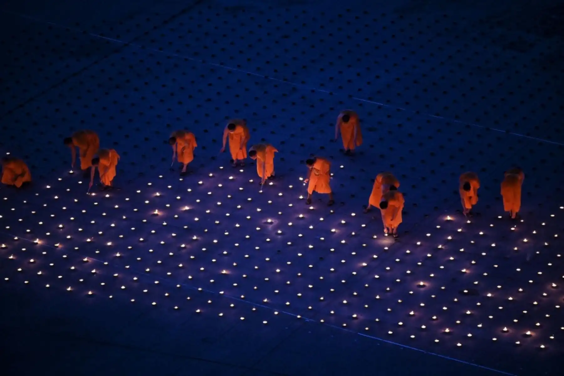 Monjes budistas encienden 330.000 velas en un intento de romper el récord mundial Guinness de la imagen en llamas más grande del mundo durante las celebraciones del Día de la Tierra en el templo budista Wat Dhammakaya en las afueras de Bangkok el 22 de abril de 2021. Foto: AFP