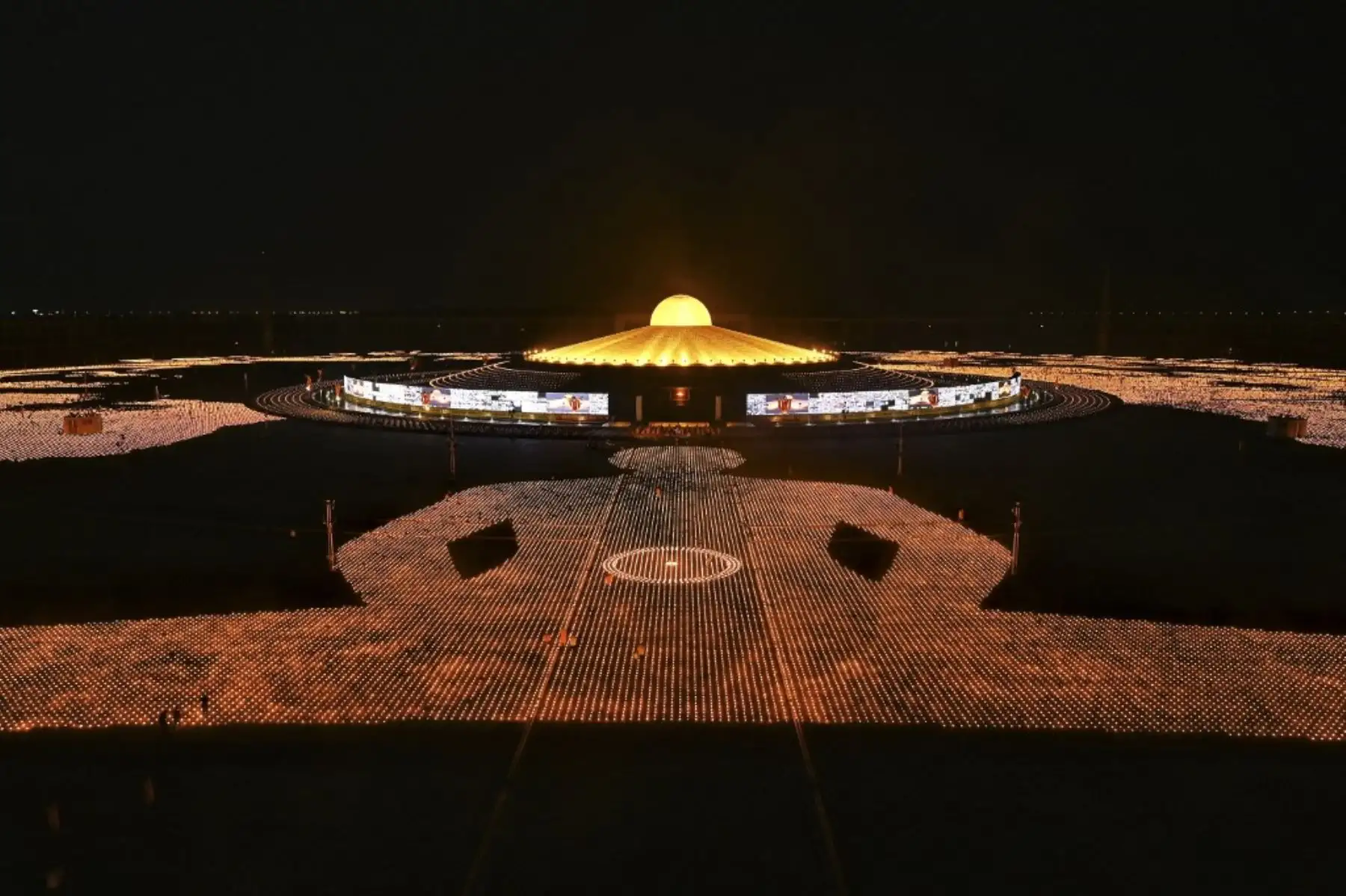 Monjes budistas encienden 330.000 velas en un intento de romper el récord mundial Guinness de la imagen en llamas más grande del mundo durante las celebraciones del Día de la Tierra en el templo budista Wat Dhammakaya en las afueras de Bangkok el 22 de abril de 2021. Foto: AFP