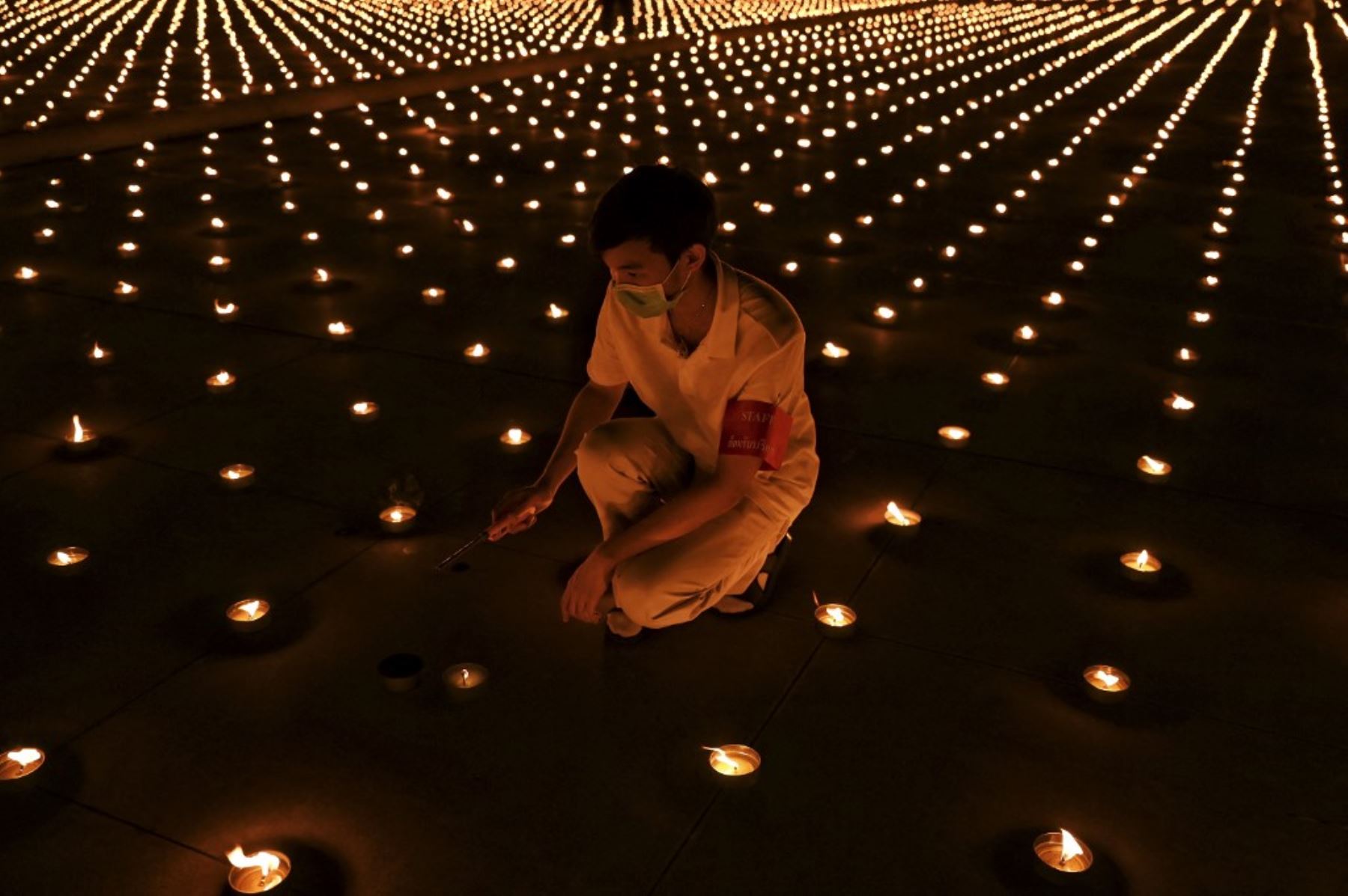 Monjes budistas encienden 330.000 velas en un intento de romper el récord mundial Guinness de la imagen en llamas más grande del mundo durante las celebraciones del Día de la Tierra en el templo budista Wat Dhammakaya en las afueras de Bangkok el 22 de abril de 2021. Foto: AFP