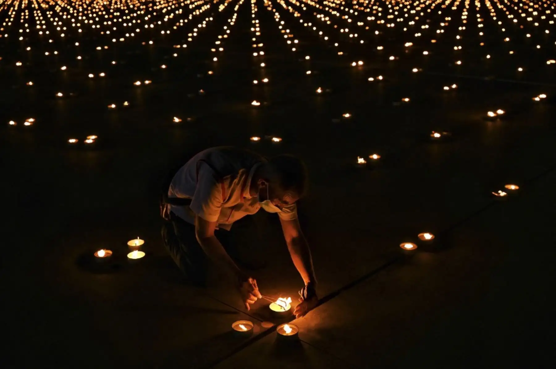 Monjes budistas encienden 330.000 velas en un intento de romper el récord mundial Guinness de la imagen en llamas más grande del mundo durante las celebraciones del Día de la Tierra en el templo budista Wat Dhammakaya en las afueras de Bangkok el 22 de abril de 2021. Foto: AFP