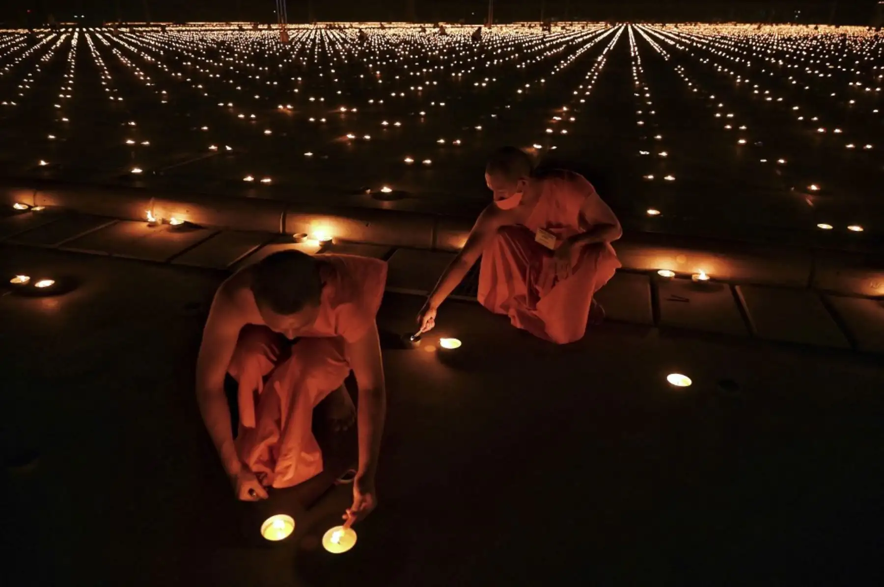 Monjes budistas encienden 330.000 velas en un intento de romper el récord mundial Guinness de la imagen en llamas más grande del mundo durante las celebraciones del Día de la Tierra en el templo budista Wat Dhammakaya en las afueras de Bangkok el 22 de abril de 2021. Foto: AFP
