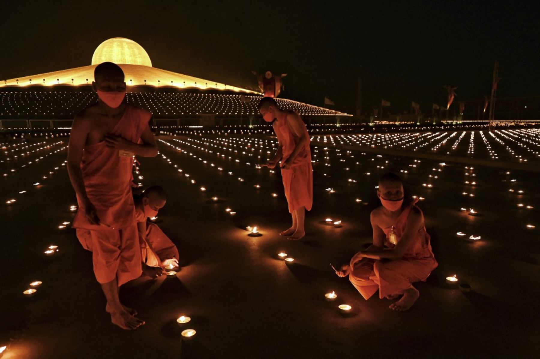 Monjes budistas encienden 330.000 velas en un intento de romper el récord mundial Guinness de la imagen en llamas más grande del mundo durante las celebraciones del Día de la Tierra en el templo budista Wat Dhammakaya en las afueras de Bangkok el 22 de abril de 2021. Foto: AFP