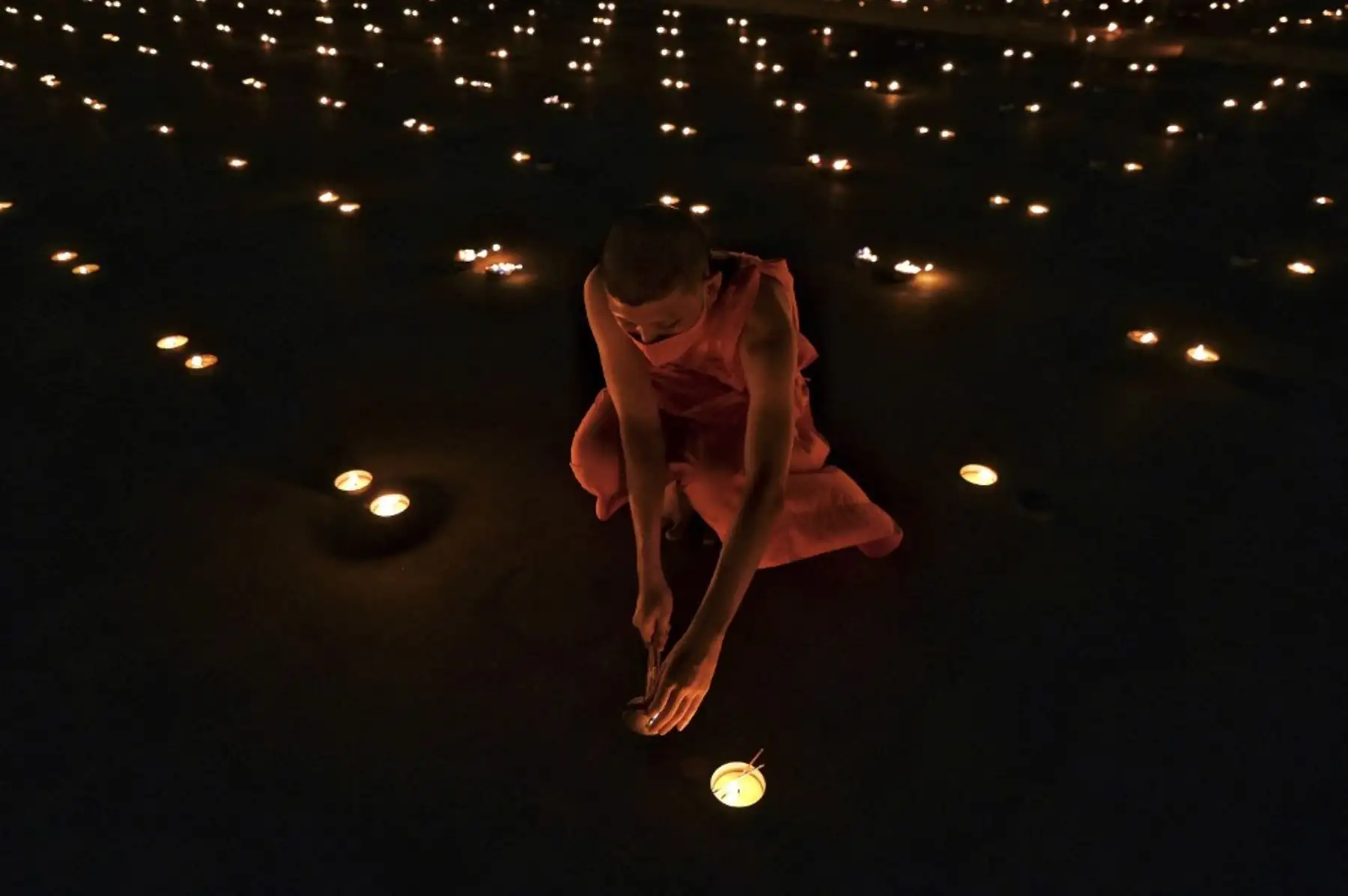 Monjes budistas encienden 330.000 velas en un intento de romper el récord mundial Guinness de la imagen en llamas más grande del mundo durante las celebraciones del Día de la Tierra en el templo budista Wat Dhammakaya en las afueras de Bangkok el 22 de abril de 2021. Foto: AFP