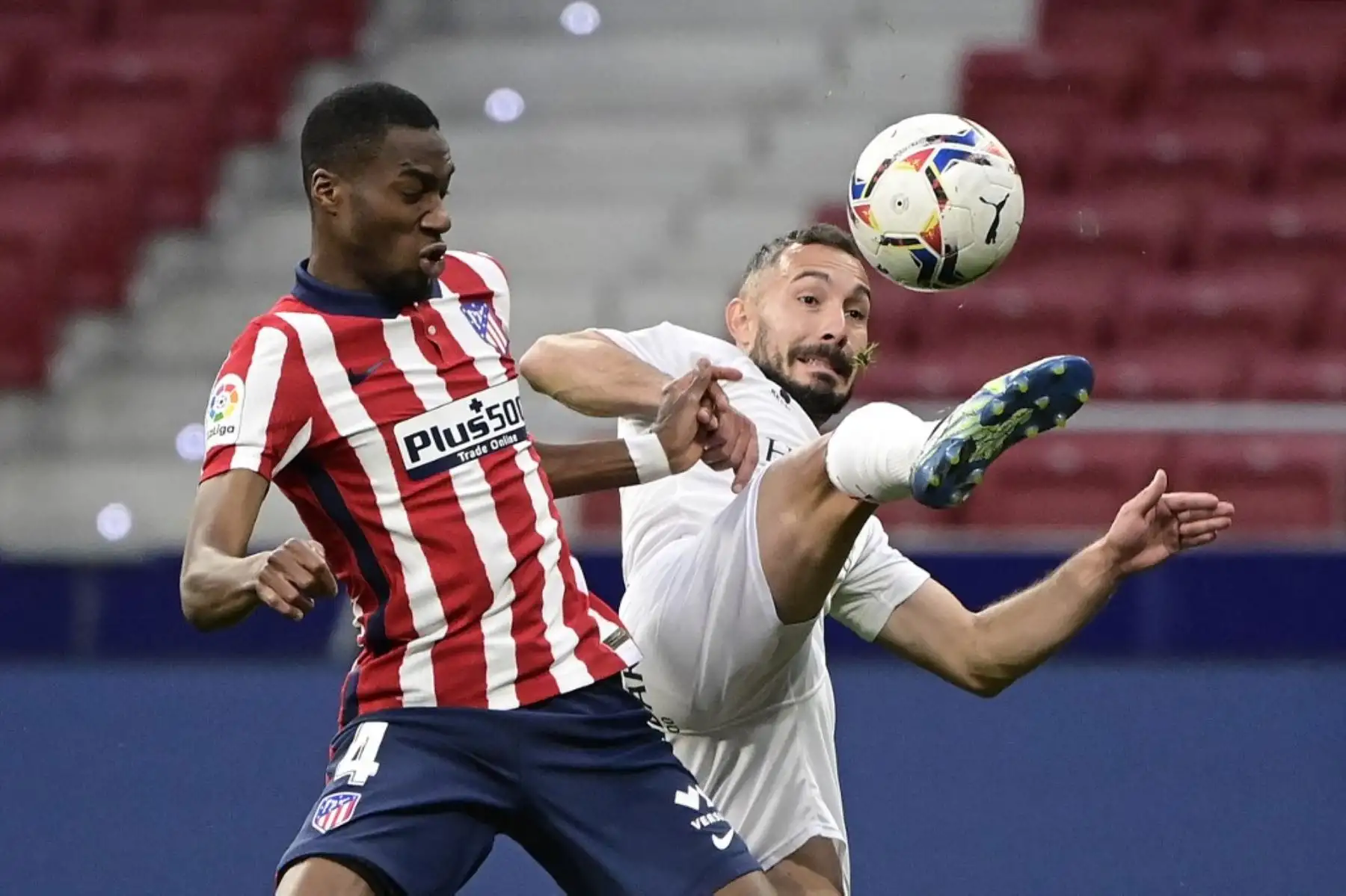 El centrocampista francés del Atlético de Madrid Geoffrey Kondogbia desafía al centrocampista español del Huesca David Ferreiro durante el partido de fútbol de la Liga española entre el Atlético de Madrid y la SD Huesca en el estadio Wanda Metropolitano de Madrid el 22 de abril de 2021. Foto: AFP