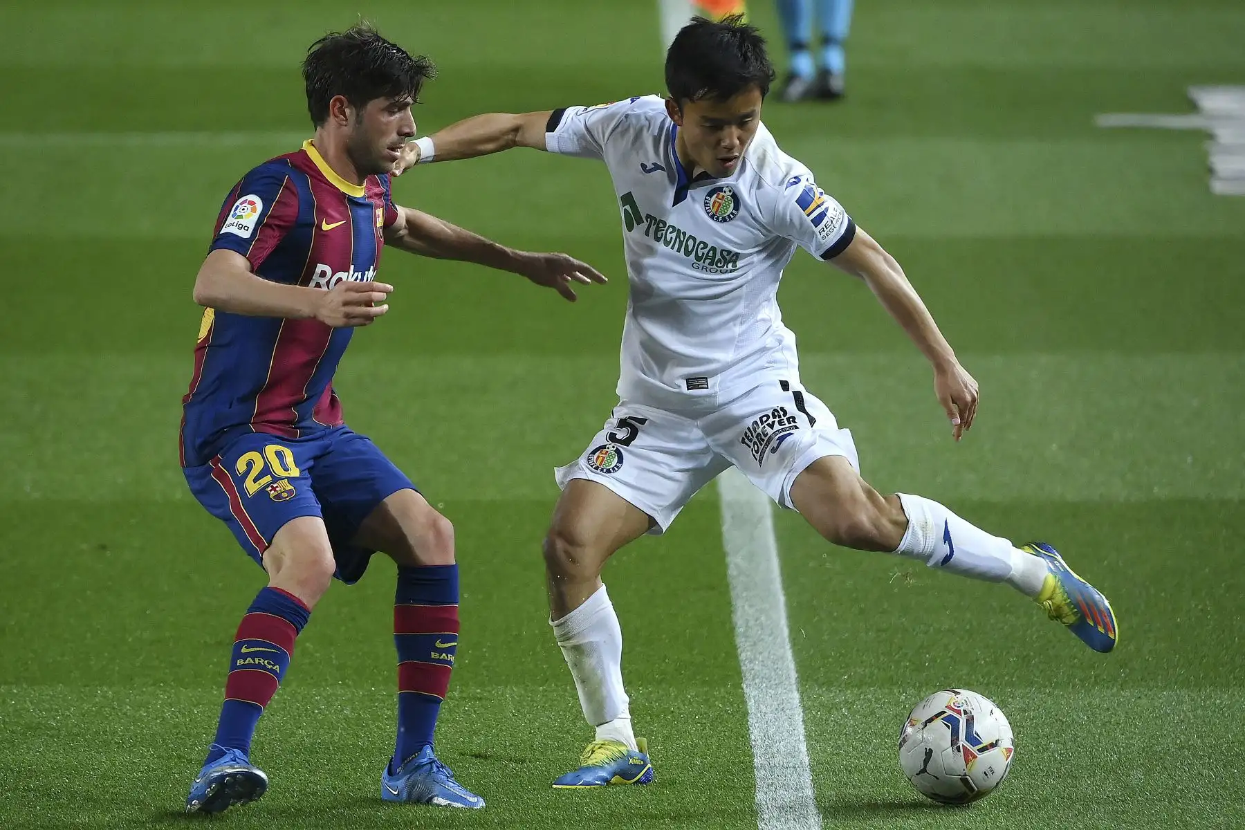 El defensa español del Barcelona Sergi Roberto desafía al mediocampista japonés del Getafe Takefusa Kubo durante el partido de fútbol de la Liga española. Foto: AFP