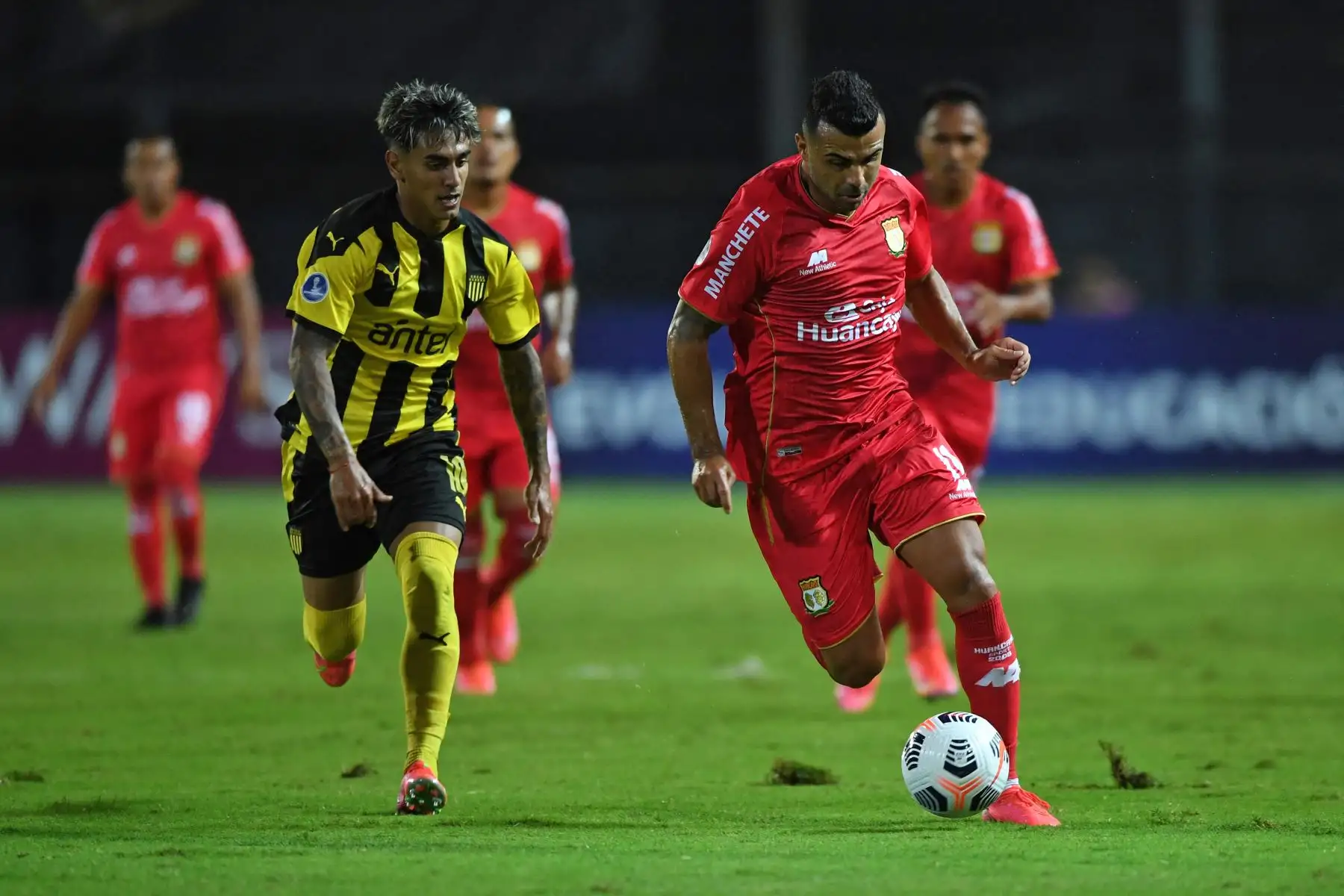 El uruguayo Facundo Torres de Peñarol y el delantero brasileño de Sport Huancayo, Liliu, compiten por el balón durante partido por la Copa Sudamericana, en el estadio Campeón del Siglo en Montevideo. Foto: AFP
