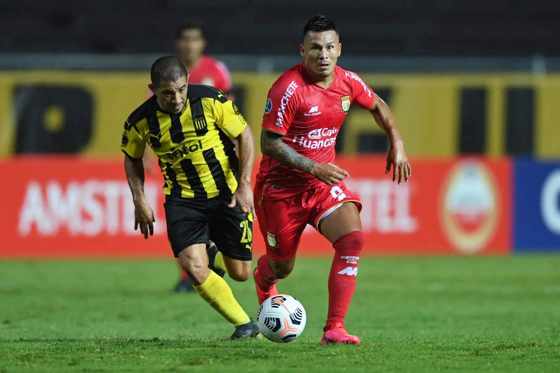 El uruguayo Walter Gargano de Peñarol y el peruano, Alfredo Rojas, de Sport Huancayo disputan el balón durante el partido por la fase de grupos de la Copa Sudamericana, en el estadio Campeón del Siglo de Montevideo. Foto: AFP