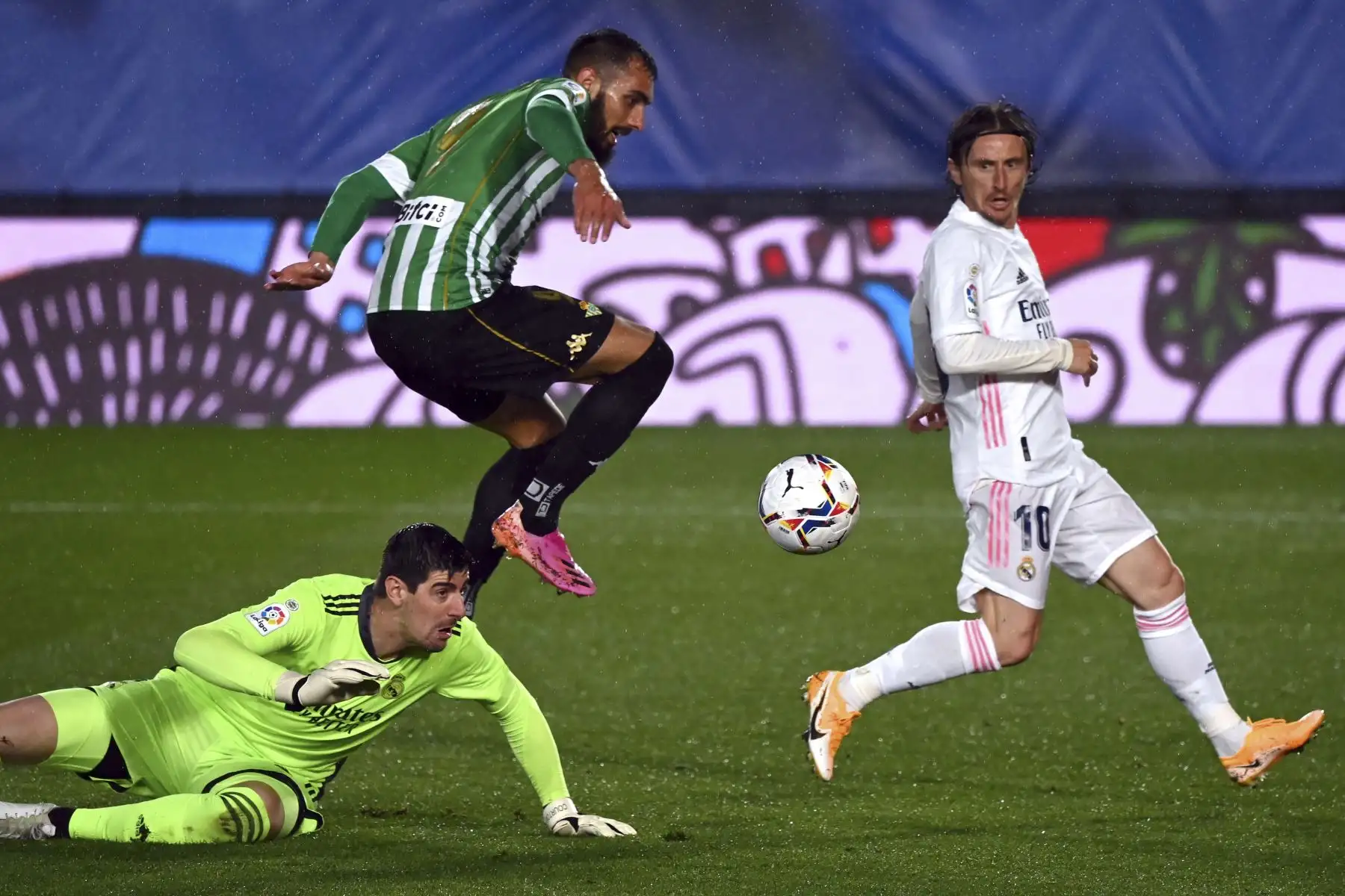 El delantero español del Real Betis, Borja Iglesias, salta sobre el portero belga del Real Madrid Thibaut Courtois durante el partido de la Liga española entre el Real Madrid CF y el Real Betis en el estadio Alfredo di Stefano de Valdebebas, en las afueras de Madrid. Foto: AFP