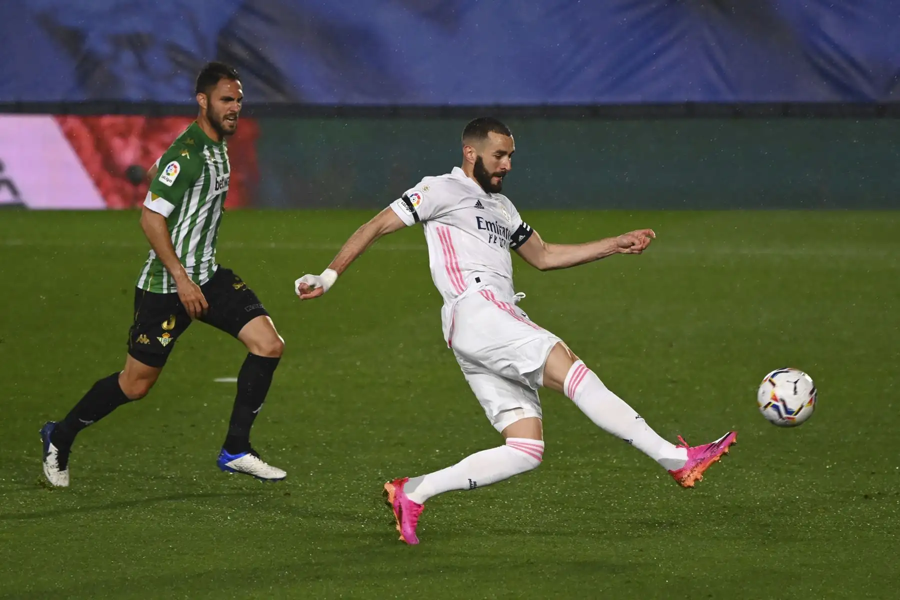 El delantero francés del Real Madrid Karim Benzema se prepara para disparar cuando el defensa español del Real Betis, Víctor Ruiz, se acerca durante el partido de fútbol de la Liga española entre el Real Madrid CF y el Real Betis en el estadio Alfredo di Stefano de Valdebebas, en las afueras de Madrid. Foto: AFP