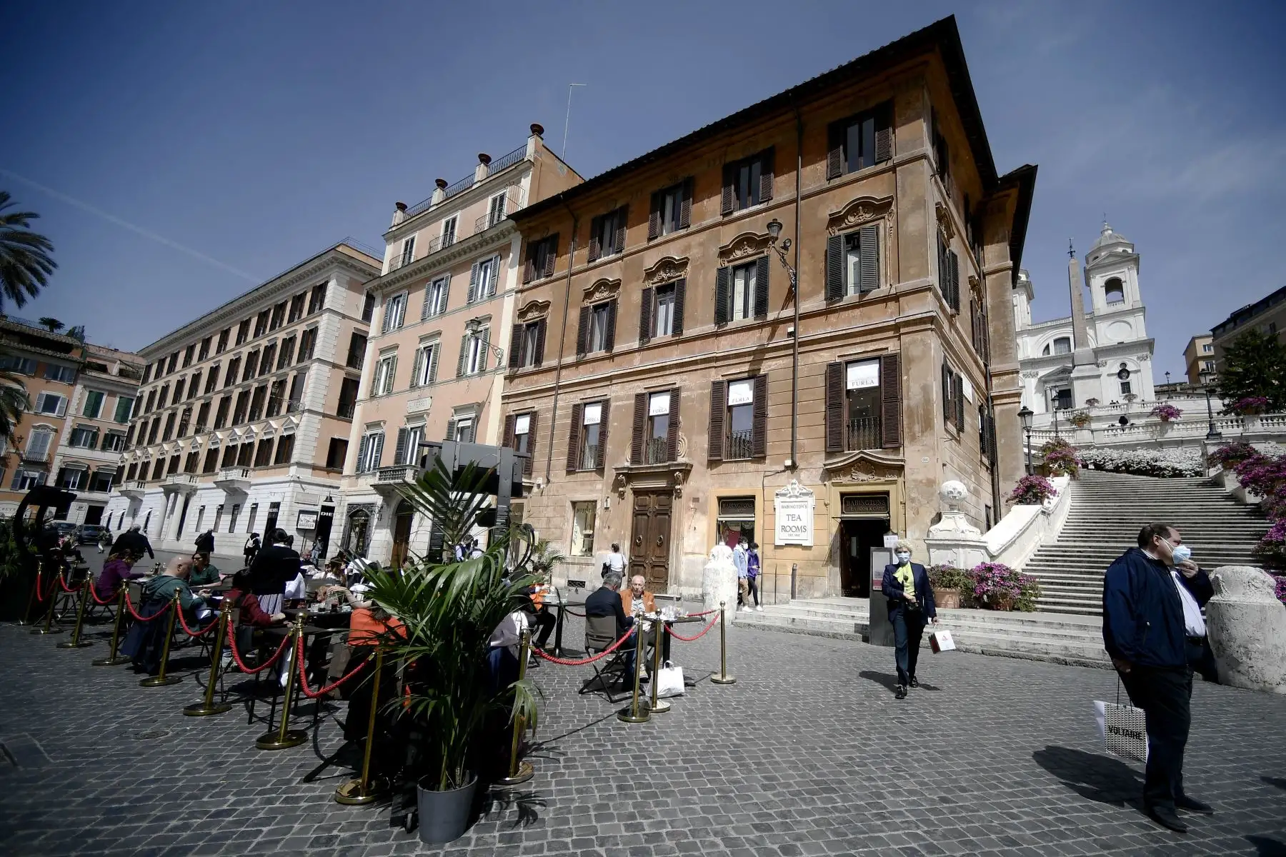 La gente almuerza en las terrazas instaladas fuera de un restaurante en la plaza central de la Plaza de España de Roma el 26 de abril de 2021. Foto: AFP