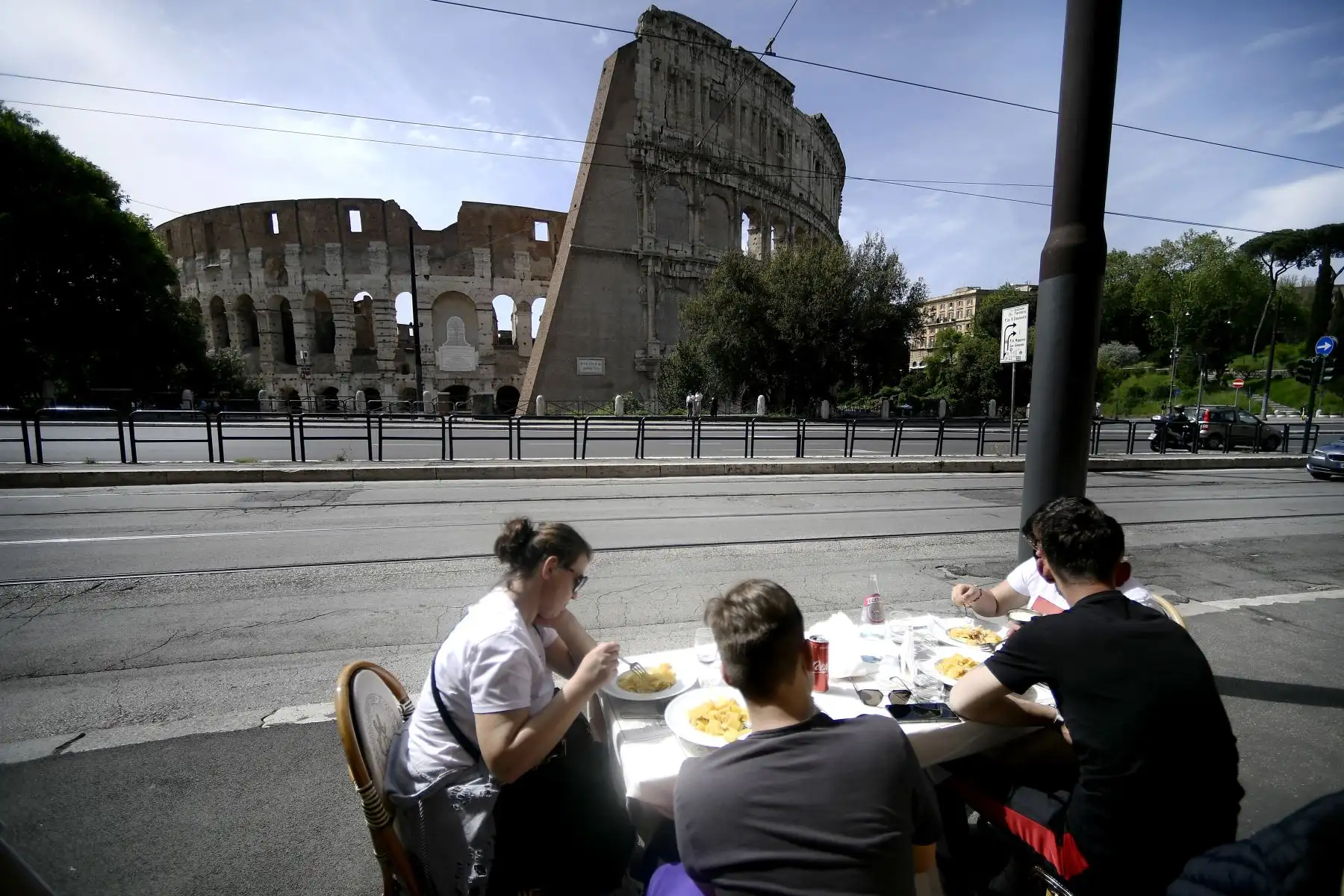 Personas almuerzan en la explanada de un restaurante frente al Coliseo en el centro de Roma, el 26 de abril de 2021, luego que Italia reabra bares, restaurantes, cines y museos luego de meses de cierre por coronavirus. Foto: AFP
