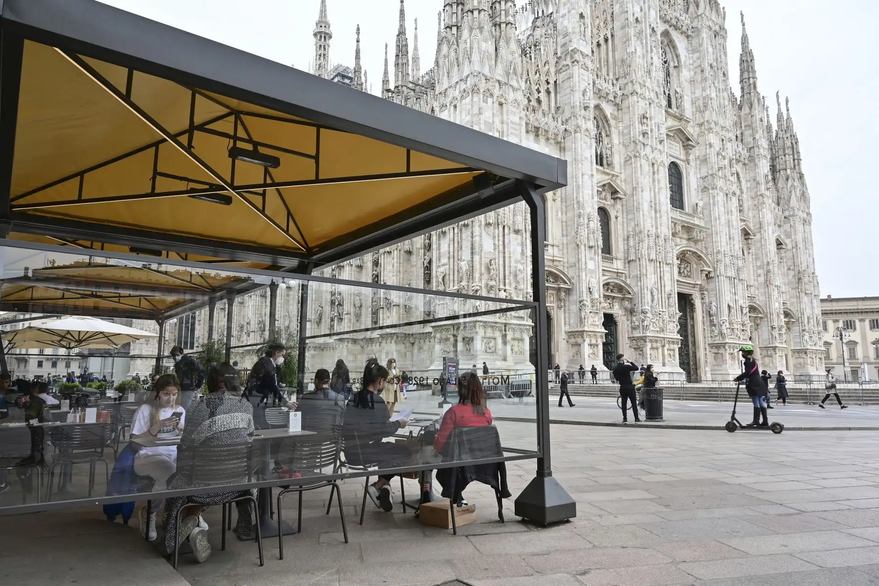 La gente almuerza en una terraza en la plaza del Duomo, el 26 de abril de 2021, en el centro de Milán. Foto: AFP