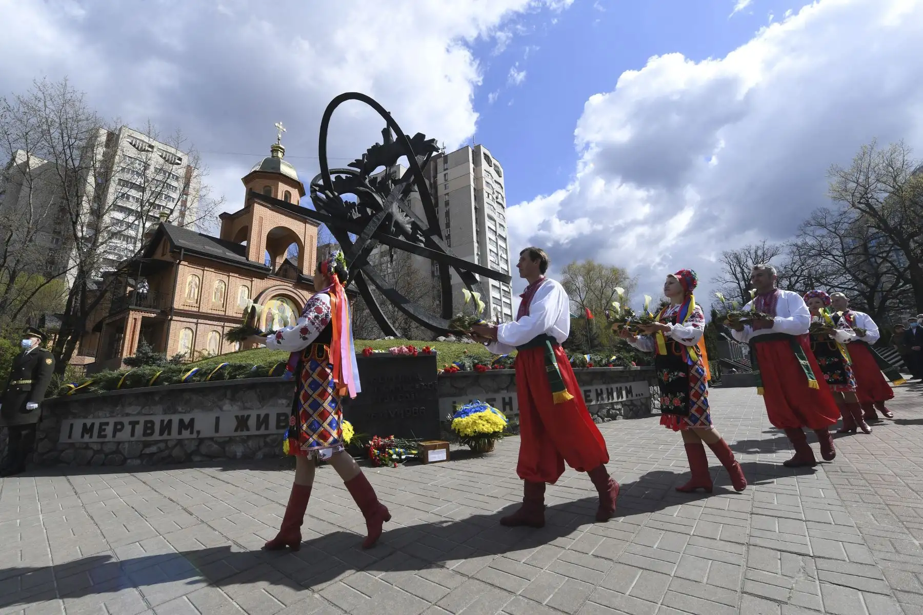 Personas vestidas con ropas tradicionales ucranianas llevan flores para presentar sus respetos en el memorial de Chernobyl en Kiev durante la conmemoración de las víctimas del desastre nuclear. Foto: AFP