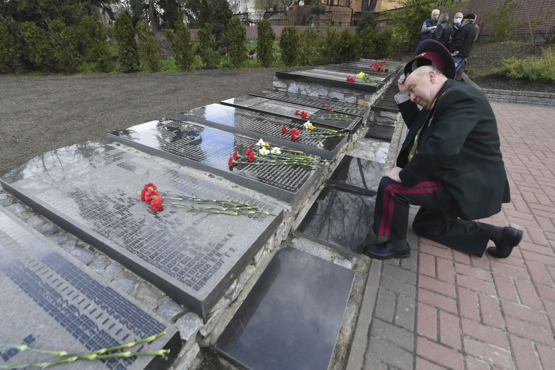 Un liquidador de la central nuclear de Chernobyl se arrodilla para presentar sus respetos en el memorial de Chernobyl en Kiev durante la conmemoración de las víctimas del desastre nuclear en el 35 aniversario. Foto:
