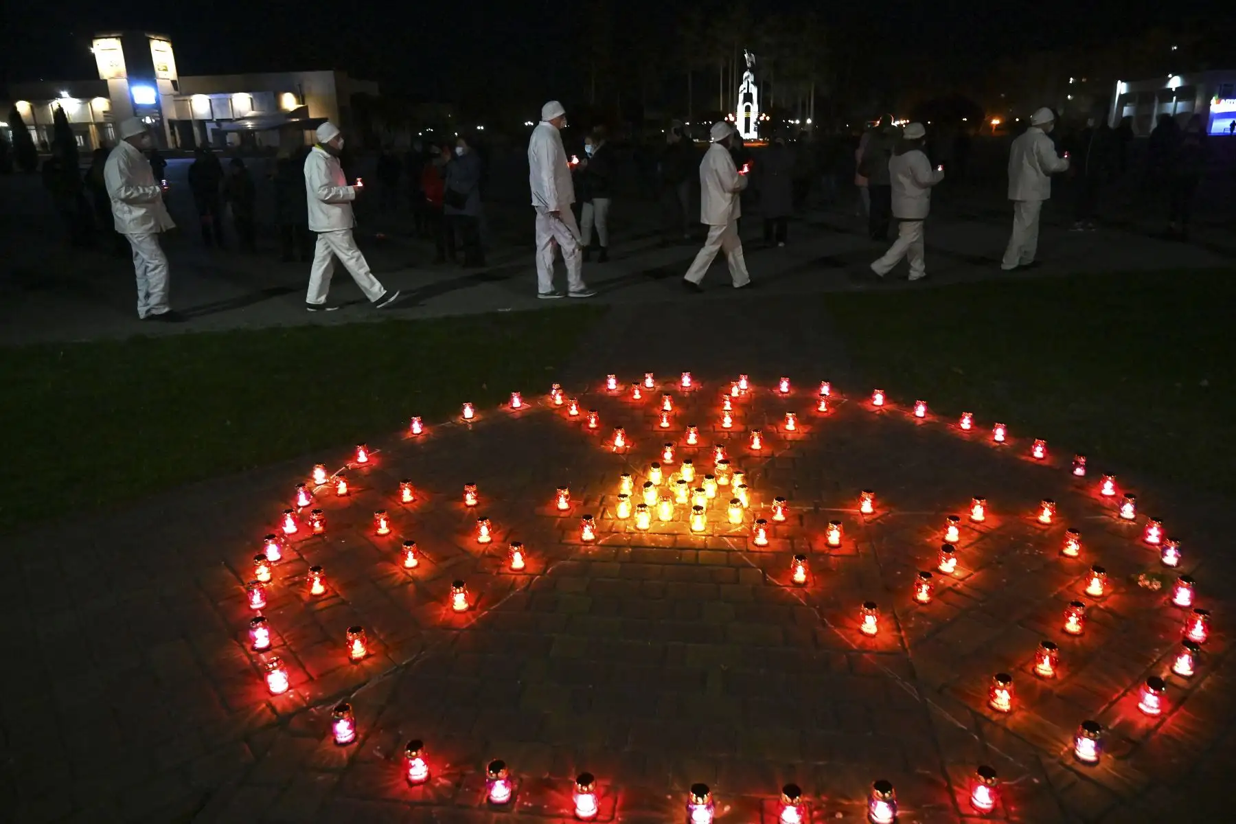 Personas llevan velas cerca del letrero de radiactividad en el monumento a las víctimas de Chernobyl, en Slavutych, la ciudad donde vivía el personal de la central eléctrica, a unos 50 kilómetros del lugar del accidente. Foto: AFP