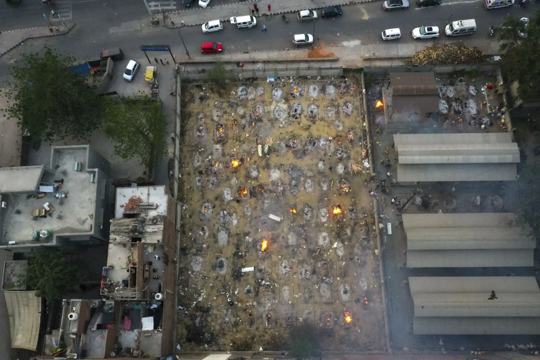 En esta fotografía aérea tomada el 26 de abril de 2021 se observan piras en llamas de víctimas que perdieron la vida debido al coronavirus, en un campo de cremación en Nueva Delhi, India. Foto: AFP