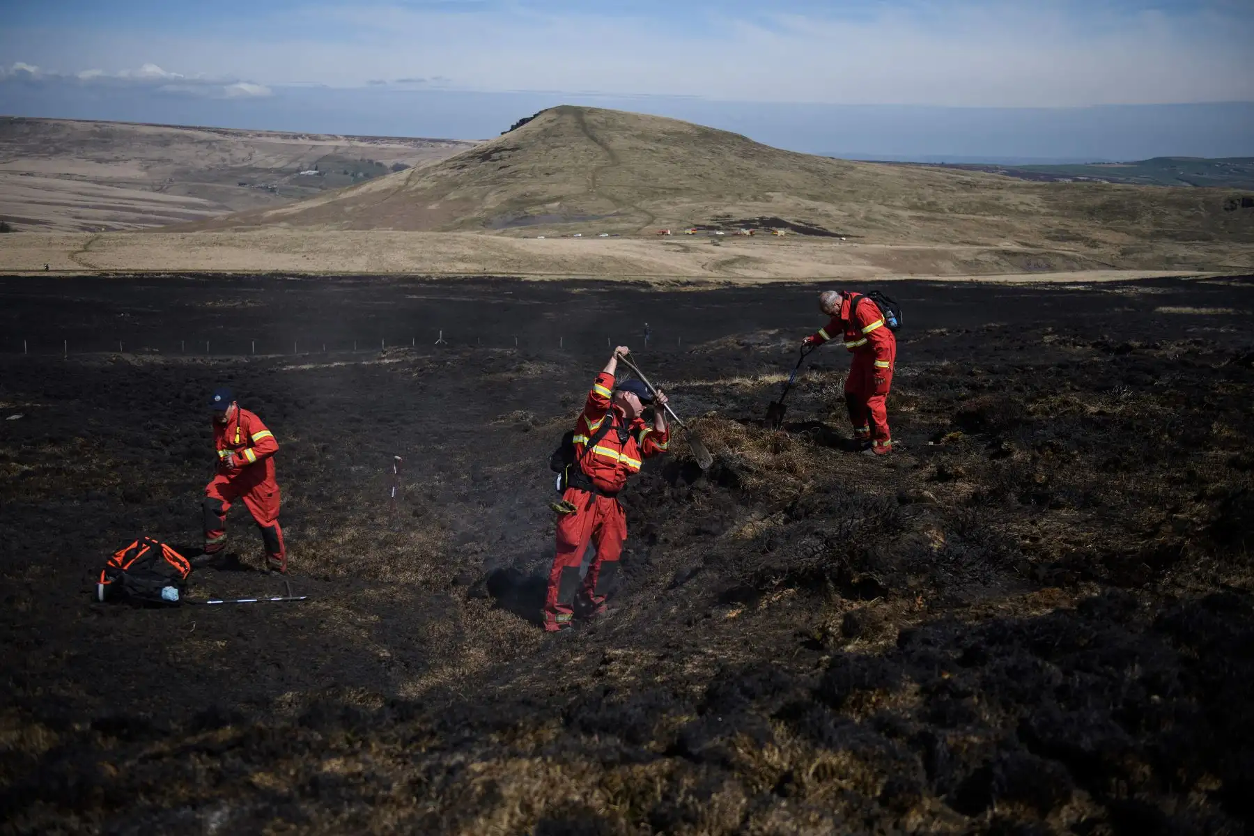 Los bomberos controlan cualquier resurgimiento de llamas en un páramo en Marsden Moor, cerca de Huddersfield, en el norte de Inglaterra. Foto: AFP