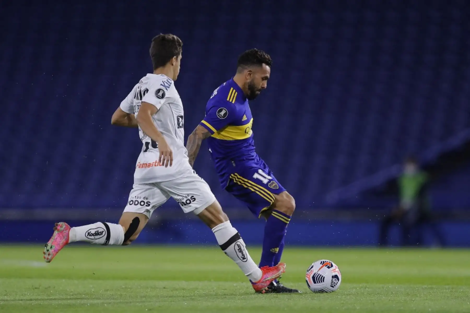 El argentino Boca Juniors Carlos Tevez y el brasileño Santos Pirani, compiten por el balón durante el partido de la fase de grupos del torneo de fútbol Copa Libertadores. Foto: AFP