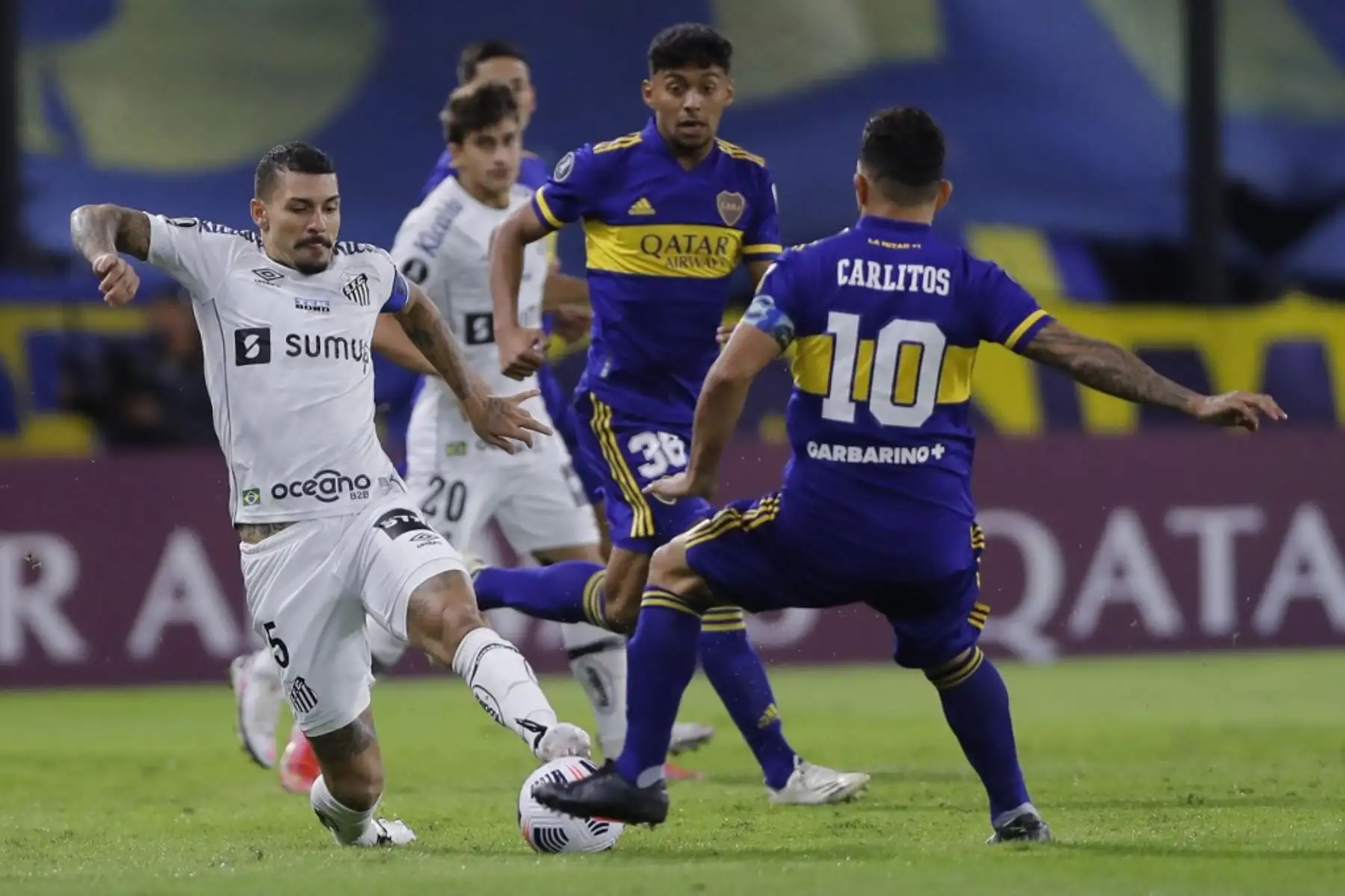El argentino de Boca Juniors Carlos Tevez y  el brasileño Santos Alison, compiten por el balón durante el partido de la fase de grupos del torneo de fútbol Copa Libertadores. Foto : AFP