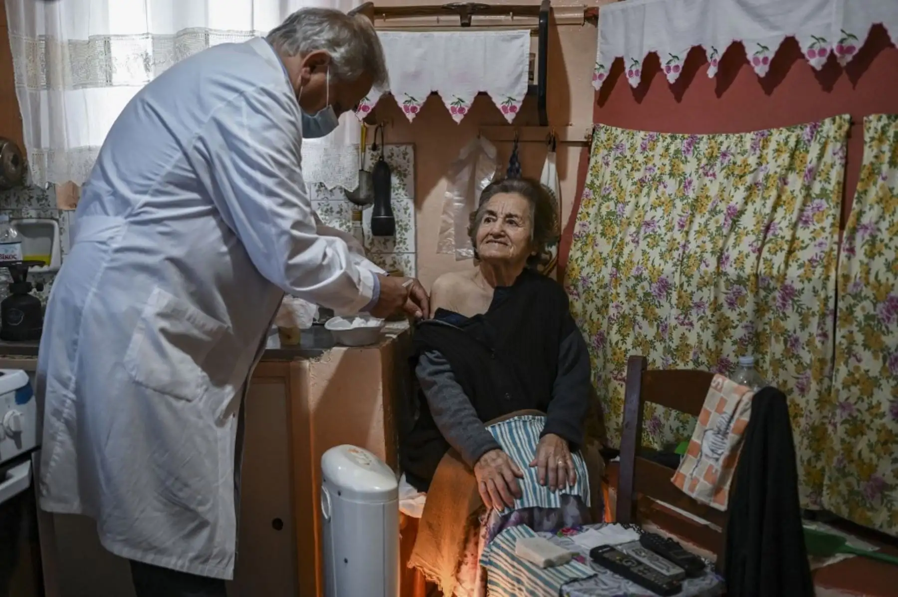 El doctor Anargyros Mariolis vacuna a una anciana contra el covid-19 que no puede visitar el centro de salud de Elafonissos, en la isla Elafonissos en Grecia. Residentes de la isla griega de Elafonissos, en el sur de Grecia, recibieron sus vacunas contra el covid. que pronto marcará el destino como libre de coviditis antes de la apertura de la temporada turística el 14 de mayo. Foto: AFP