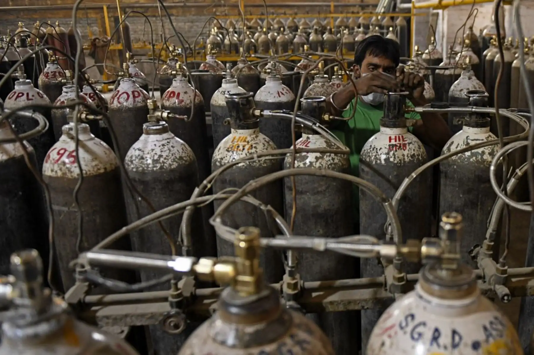 Se ve a trabajadores clasificando cilindros de oxígeno que se utilizan para pacientes con coronavirus covid-19 antes de enviarlos a hospitales en una instalación en las afueras de Amritsar el 28 de abril de 2021. Foto: AFP