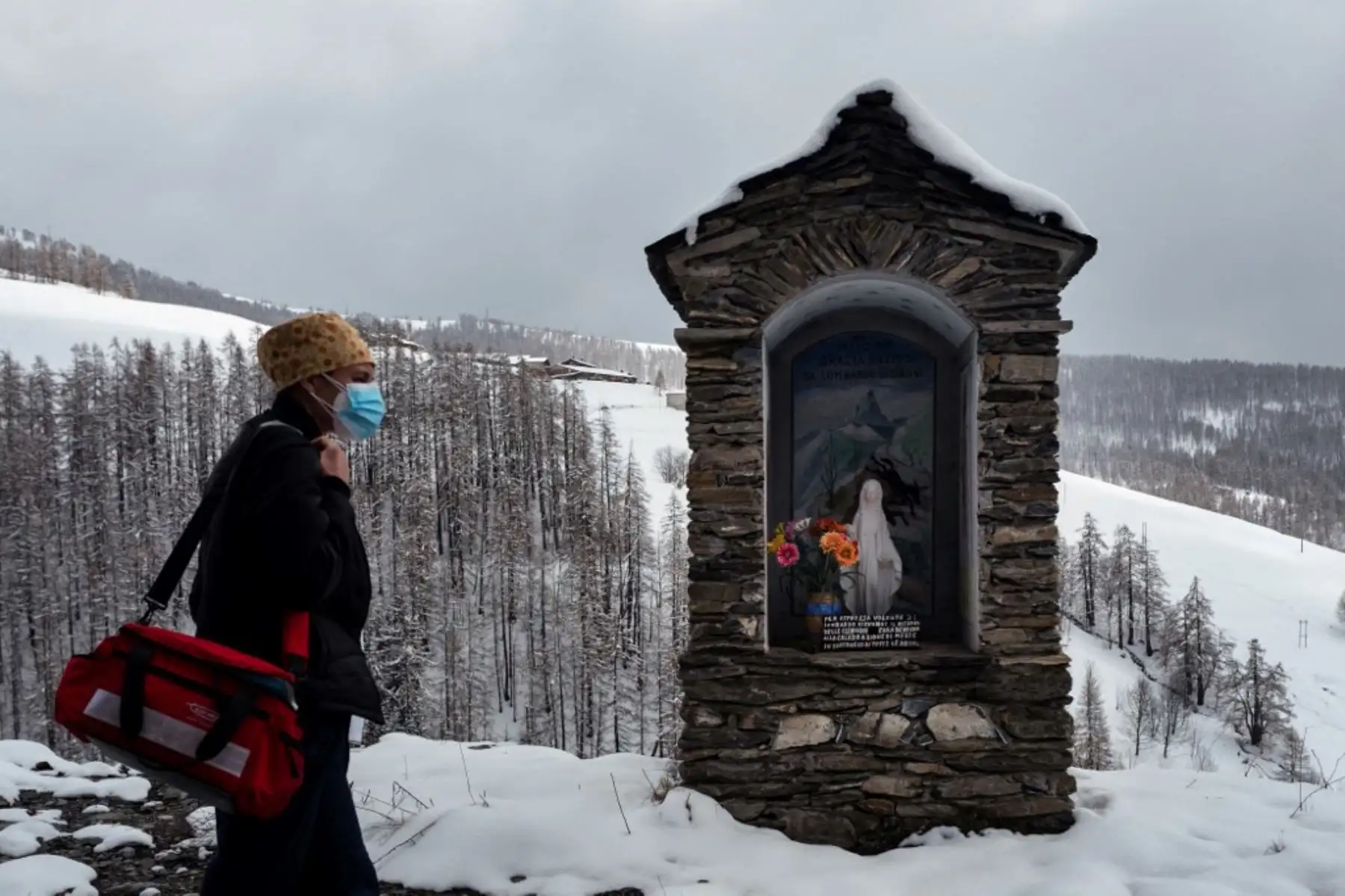 Una trabajadora médica pasa junto a un altar mientras va de casa en casa en Elva, Valle de Maira, cerca de Cuneo, noroeste de Italia, durante una campaña de vacunación domiciliaria, para residentes mayores de 80 años, con el Covid- 19 Vacuna Moderna. Foto: AFP