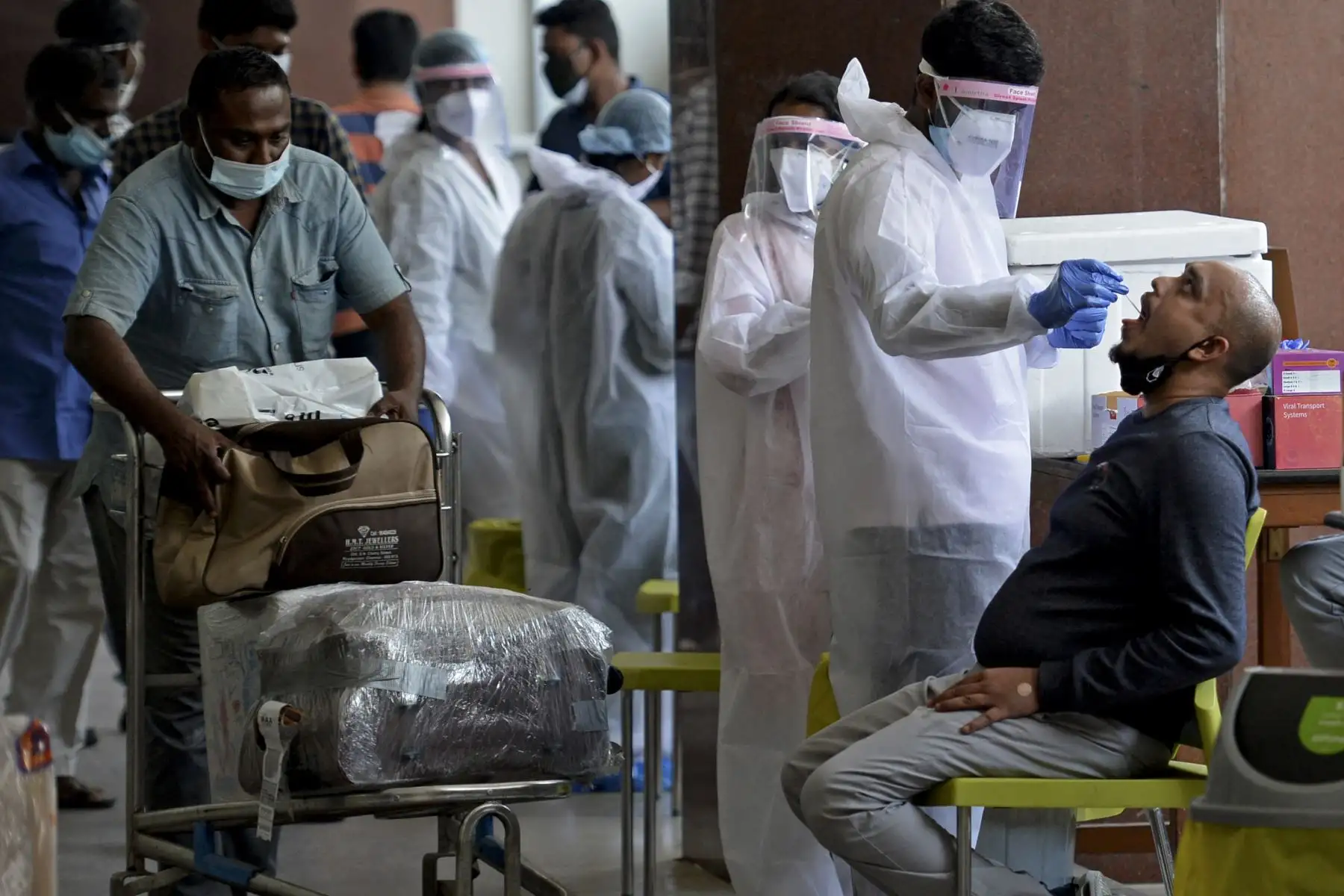 Los pasajeros que llegan en vuelos internacionales se someten a una prueba de detección del coronavirus Covid-19 en el aeropuerto internacional Anna en Chennai, India. Foto: AFP