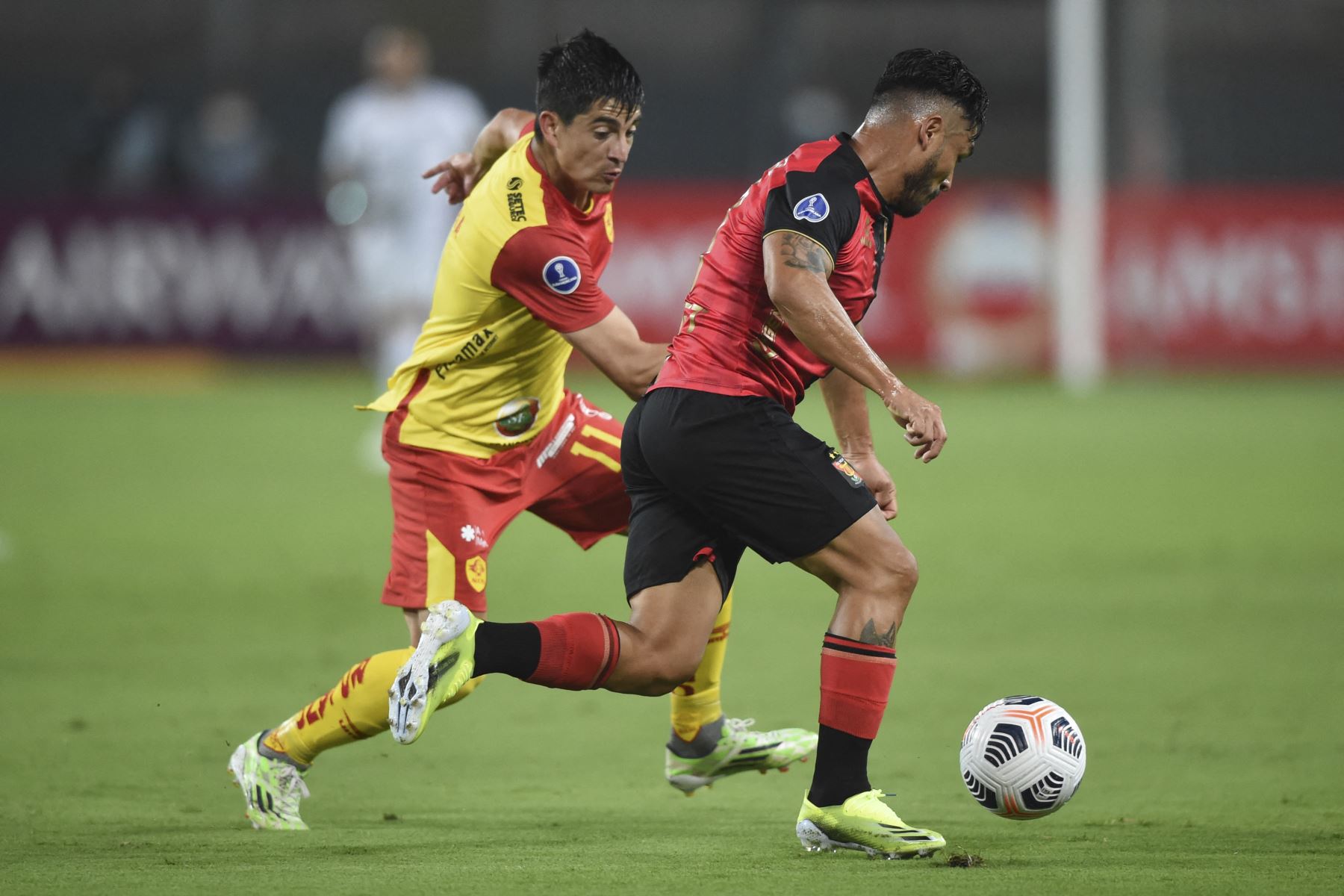 El jugador peruano de Melgar Joel Sánchez  y el chileno de Aucas de Ecuador, Ignacio Herrera, compiten por el balón durante el partido de la fase de grupos de la Copa Sudamericana de fútbol en el Estadio Nacional de Lima.