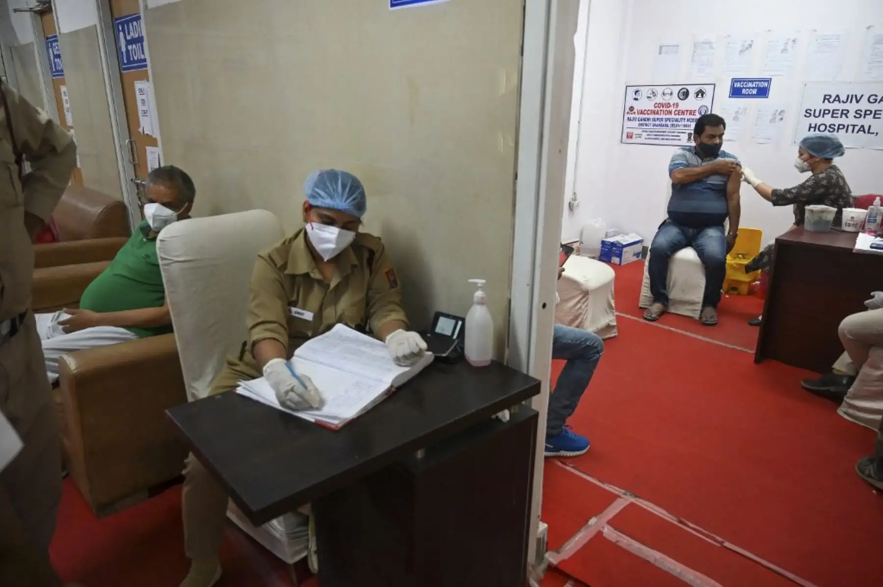 Un trabajador médico inocula a un hombre con una dosis de la vacuna contra el coronavirus Covishield Covid-19 en el hospital Rajiv Gandhi Super Specialty en Nueva Delhi. Foto: AFP