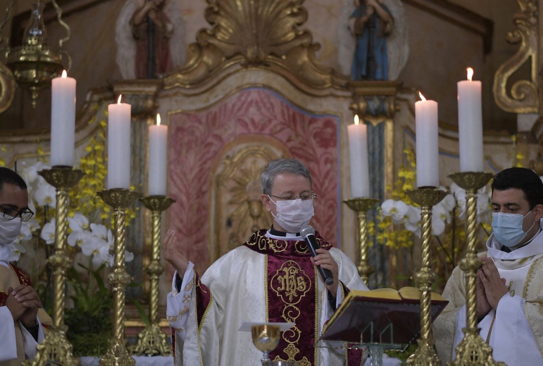 Sacerdotes con mascarillas protectoras como medida de precaución contra la propagación del nuevo coronavirus, participan en una misa en la iglesia de Santo Antonio en Mateus Leme, estado de Minas Gerais, Brasil. Foto: AFP