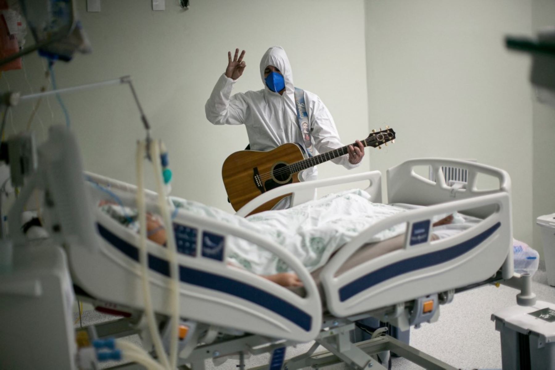 Un trabajador de salud del hospital de caridad portugués en Belem, estado de Pará, Brasil, canta y reza por un paciente de covid-19 dentro de las salas del hospital y las áreas de la UCI. Foto: AFP