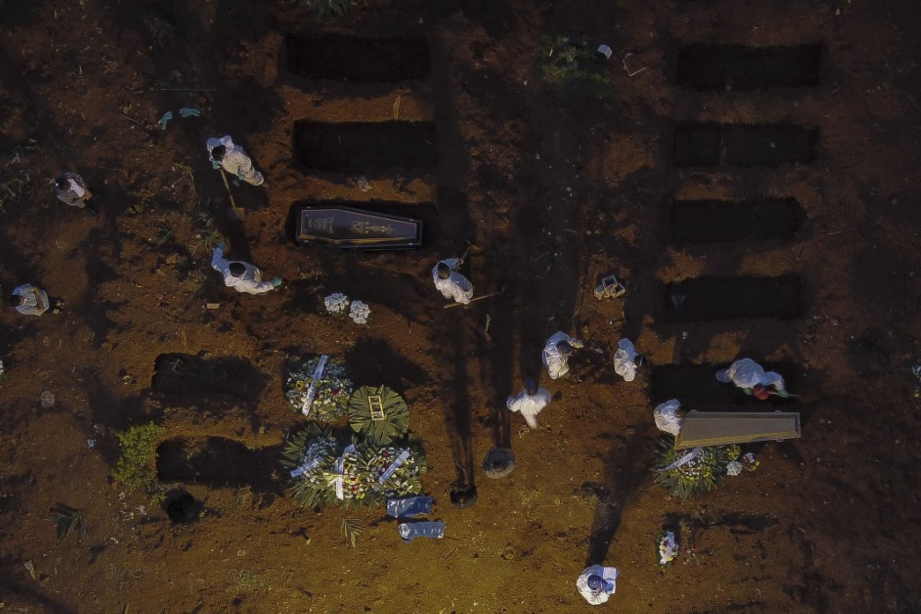Vista aérea que muestra a trabajadores con equipo de protección como medida preventiva contra la propagación de la enfermedad del nuevo coronavirus, covid-19, enterrando ataúdes en el cementerio de Vila Formosa en Sao Paulo, Brasil. Foto: AFP