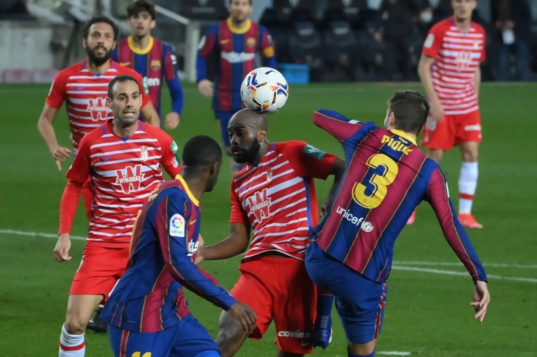 El defensa francés del Granada Dimitri Foulquier (C) cabecea el balón durante el partido de fútbol de la Liga española entre Barcelona y Granada en el estadio Camp Nou de Barcelona el 29 de abril de 2021. Foto: AFP
