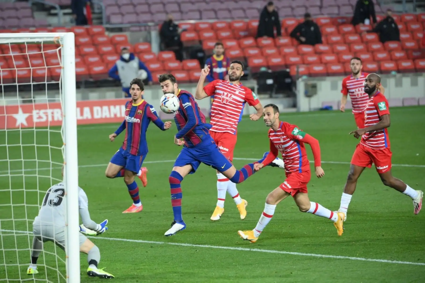 El defensa español del Barcelona Gerard Piqué (C) salta por el balón durante el partido de fútbol de la Liga española entre el Barcelona y el Granada en el estadio Camp Nou de Barcelona el 29 de abril de 2021. Foto: AFP