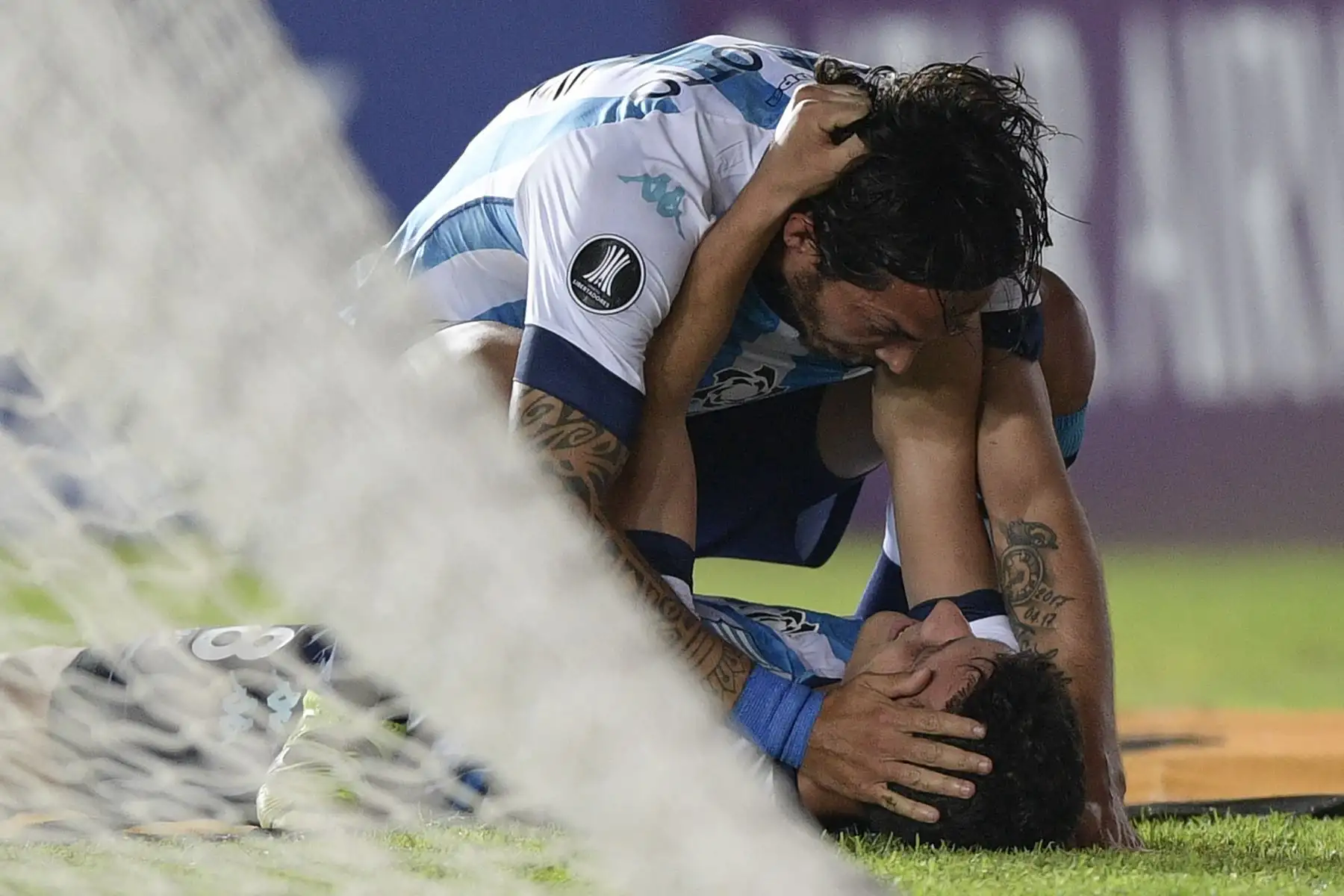 Tomas Chancalay celebra con su compañero Matías Schelotto  de Racing Club tras anotar ante el Sporting Cristal durante partido por la Copa Libertadores. Foto: AFP