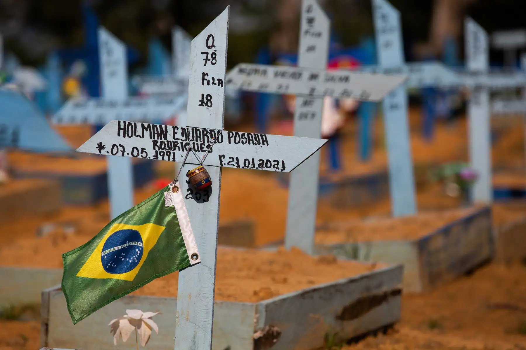 En la tumba de una víctima del COVID-19 se observa una bandera brasileña en el cementerio de Nossa Senhora Aparecida en Manaus, estado de Amazonas, Brasil, el 29 de abril de 2021. Foto: AFP