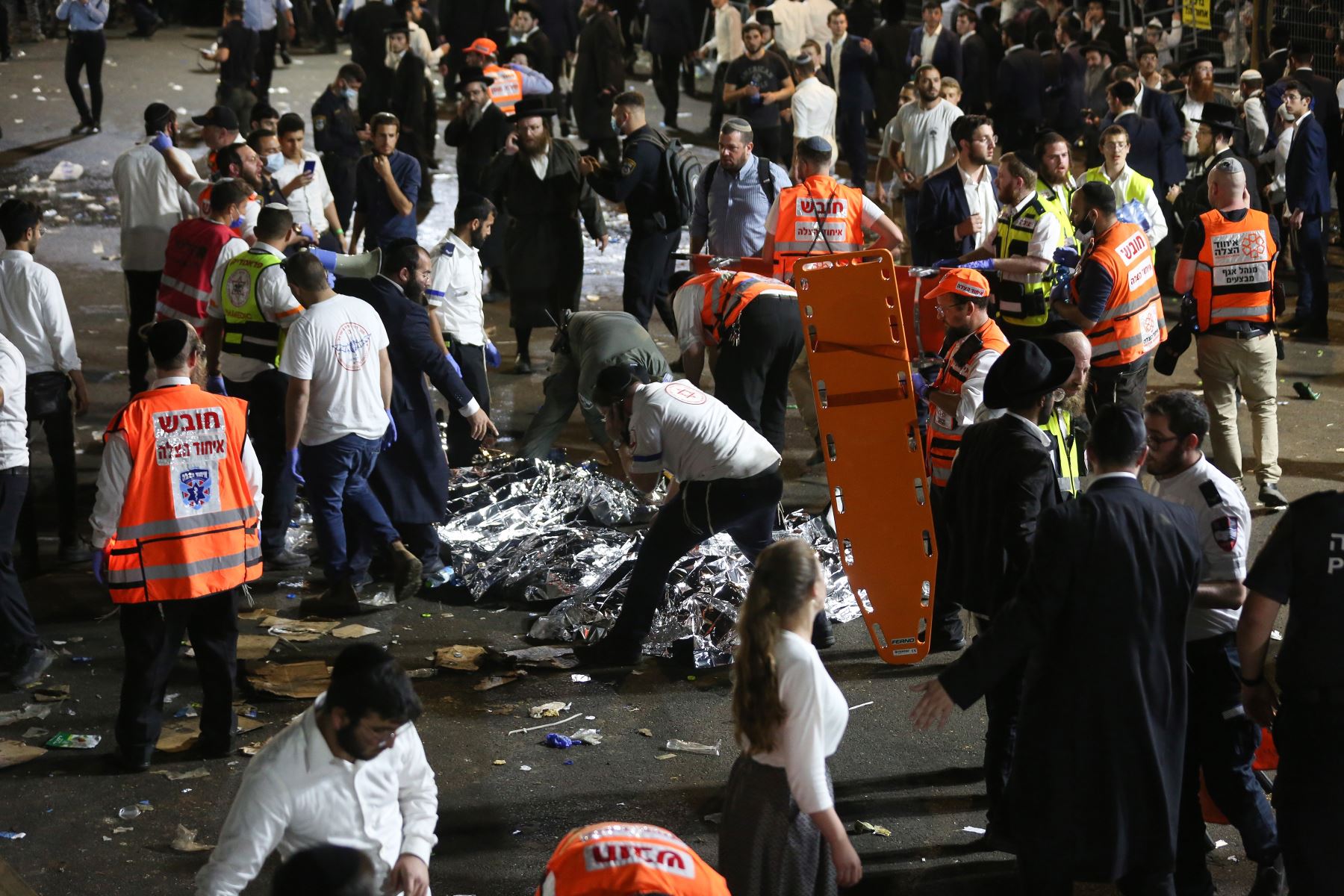 Funcionarios de seguridad y rescatistas israelíes inspeccionan los cadáveres de decenas de judíos ultraortodoxos durante Lag Ba